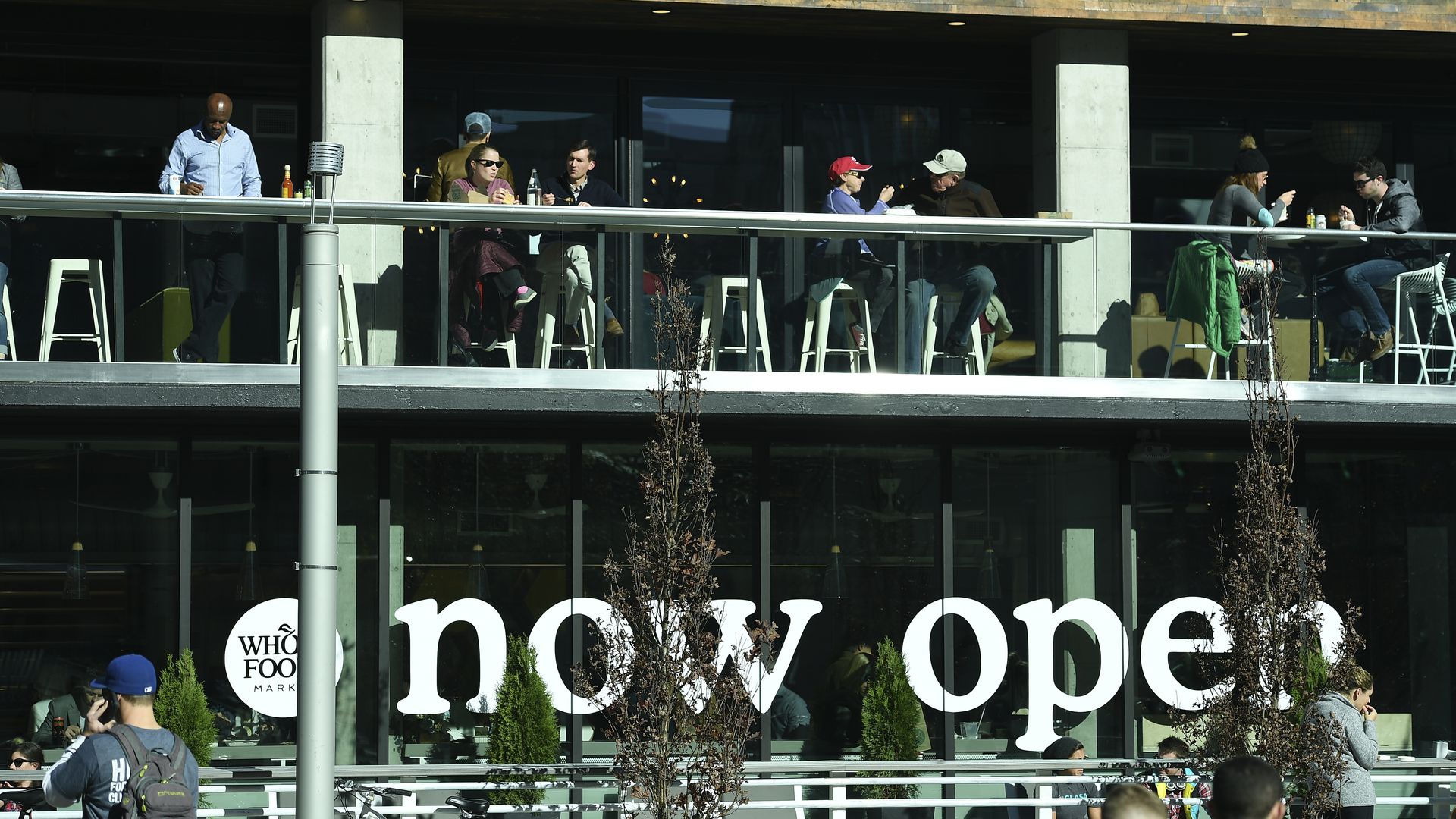 Photo of a Whole Foods Market with the words "now open" written on the windows.