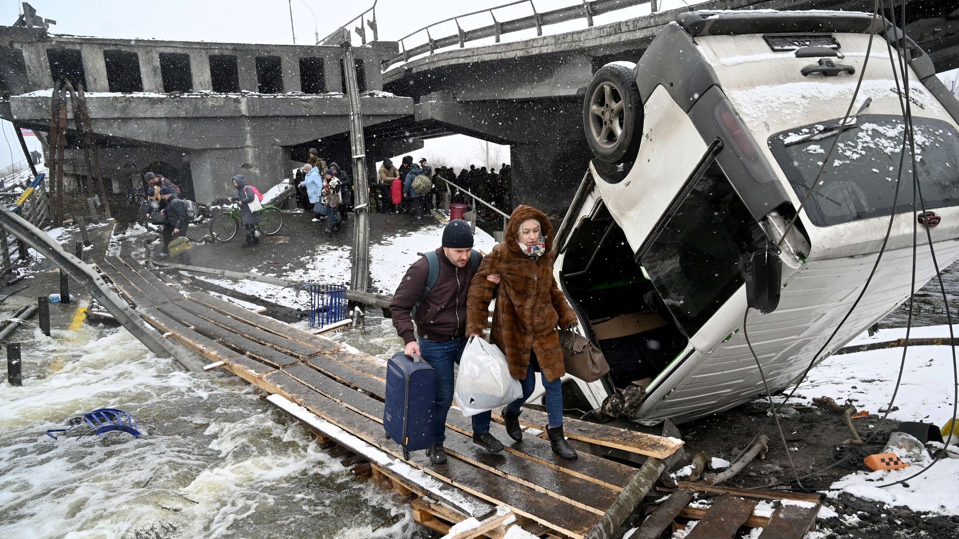 A couple crosses a destroyed bridge during the evacuation by civilians of the city of Irpin, northwest of Kyiv, on March 8.