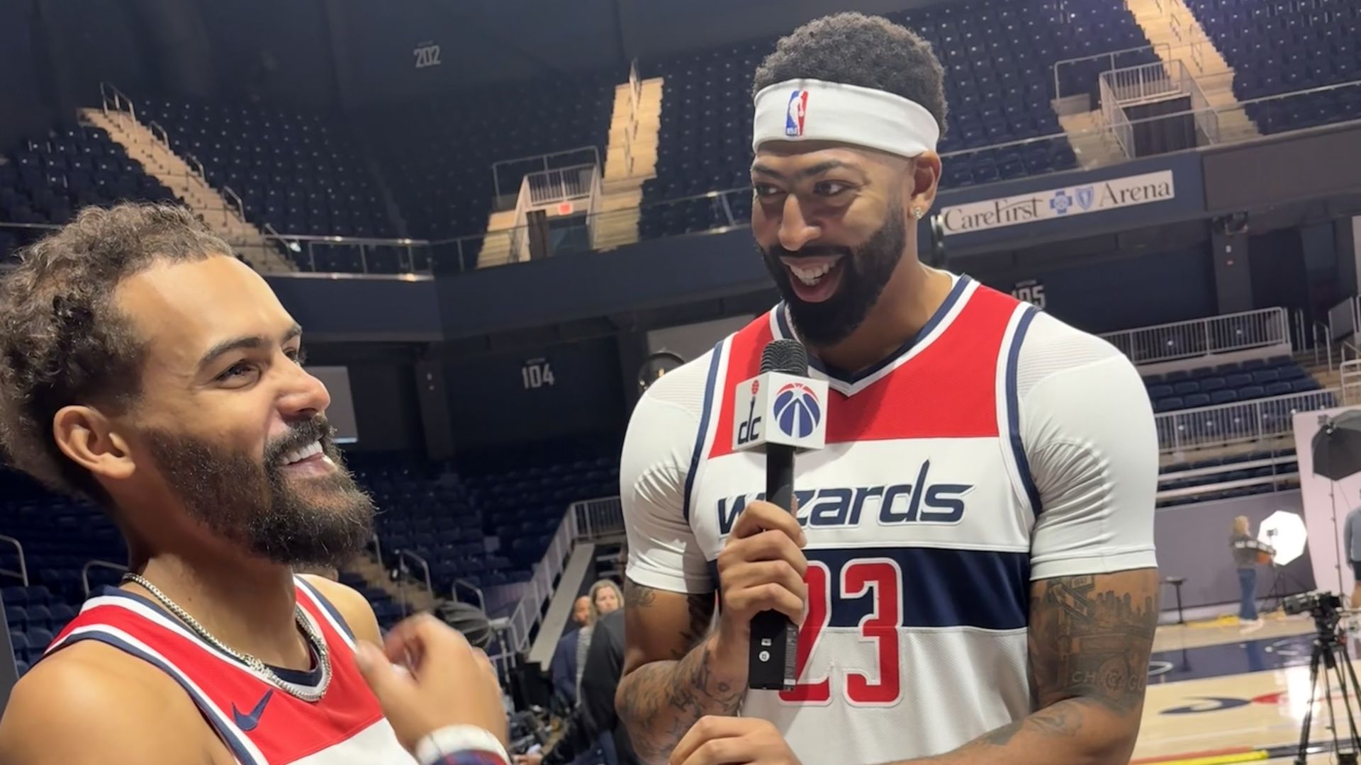 Wizards players Anthony Davis and Trae Young speak on the basketball court.