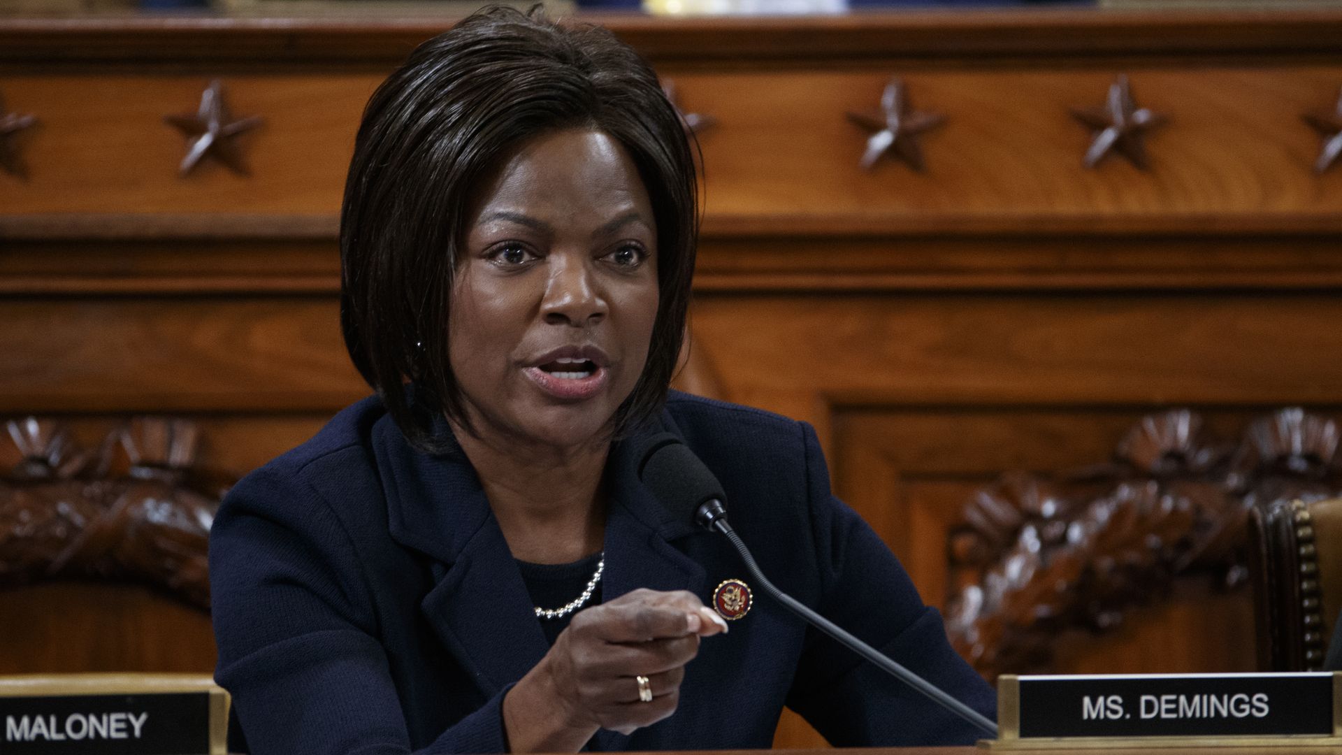 a photo of Val Demings sitting at a dais.
