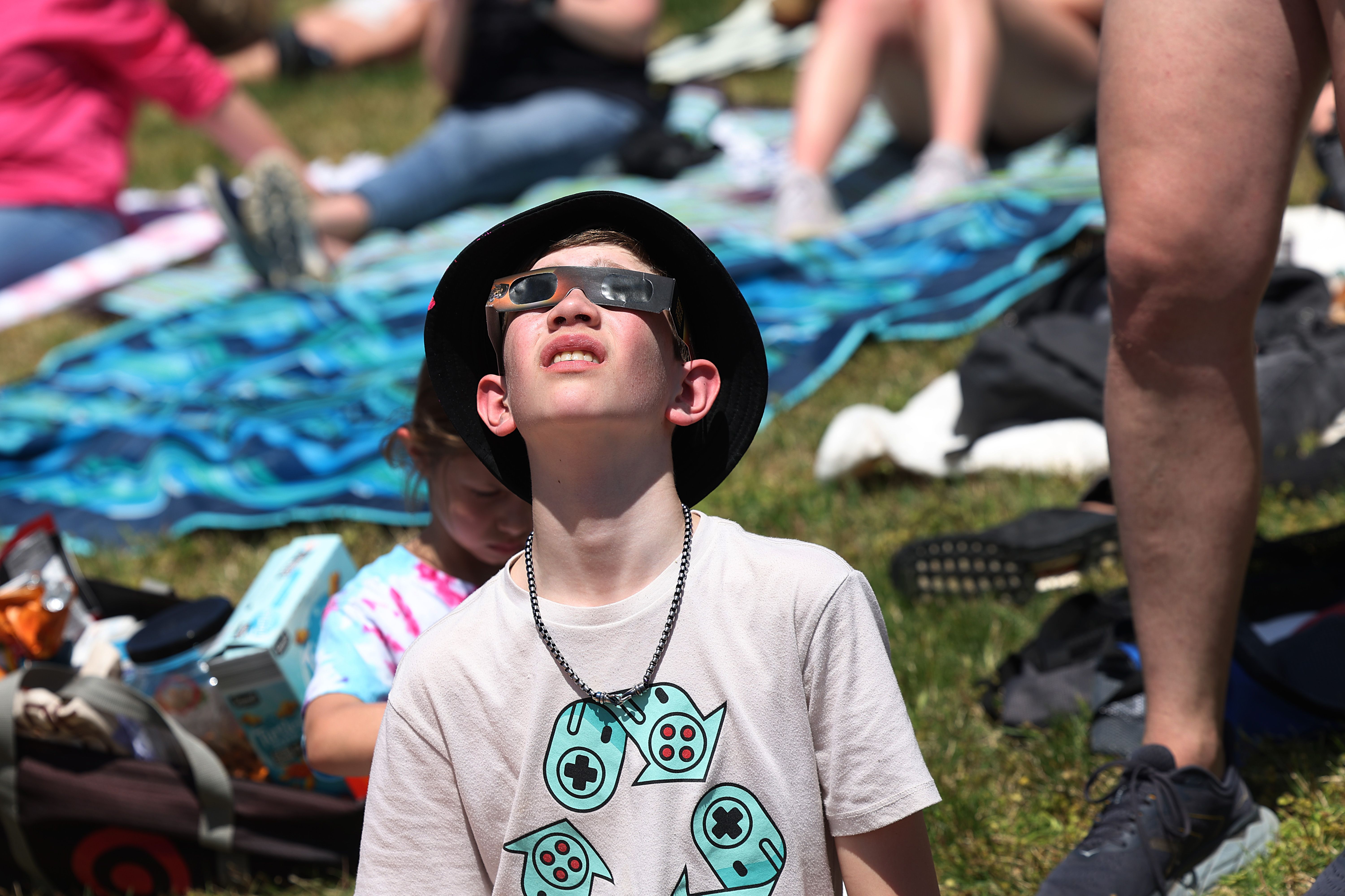 CARBONDALE, ILLINOIS - APRIL 08: People prepare for the start of the total eclipse on the campus of Southern Illinois University on April 08, 2024 in Carbondale, Illinois. People have travelled from around the country to the campus to view the rare celestial phenomenon. Cities around the country that are in the path of totality are experiencing a similar influx of tourists. (Photo by Scott Olson/Getty Images)