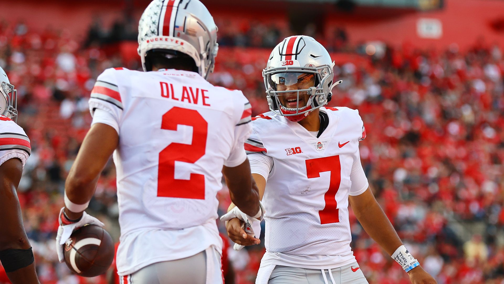 Two Ohio State players shake hands in celebration after scoring a touchdown. 