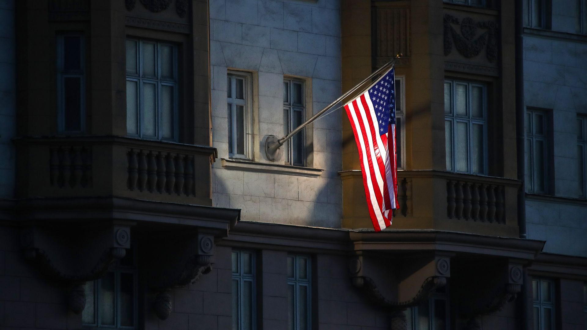 Photo of an American flag hanging from the side of a building