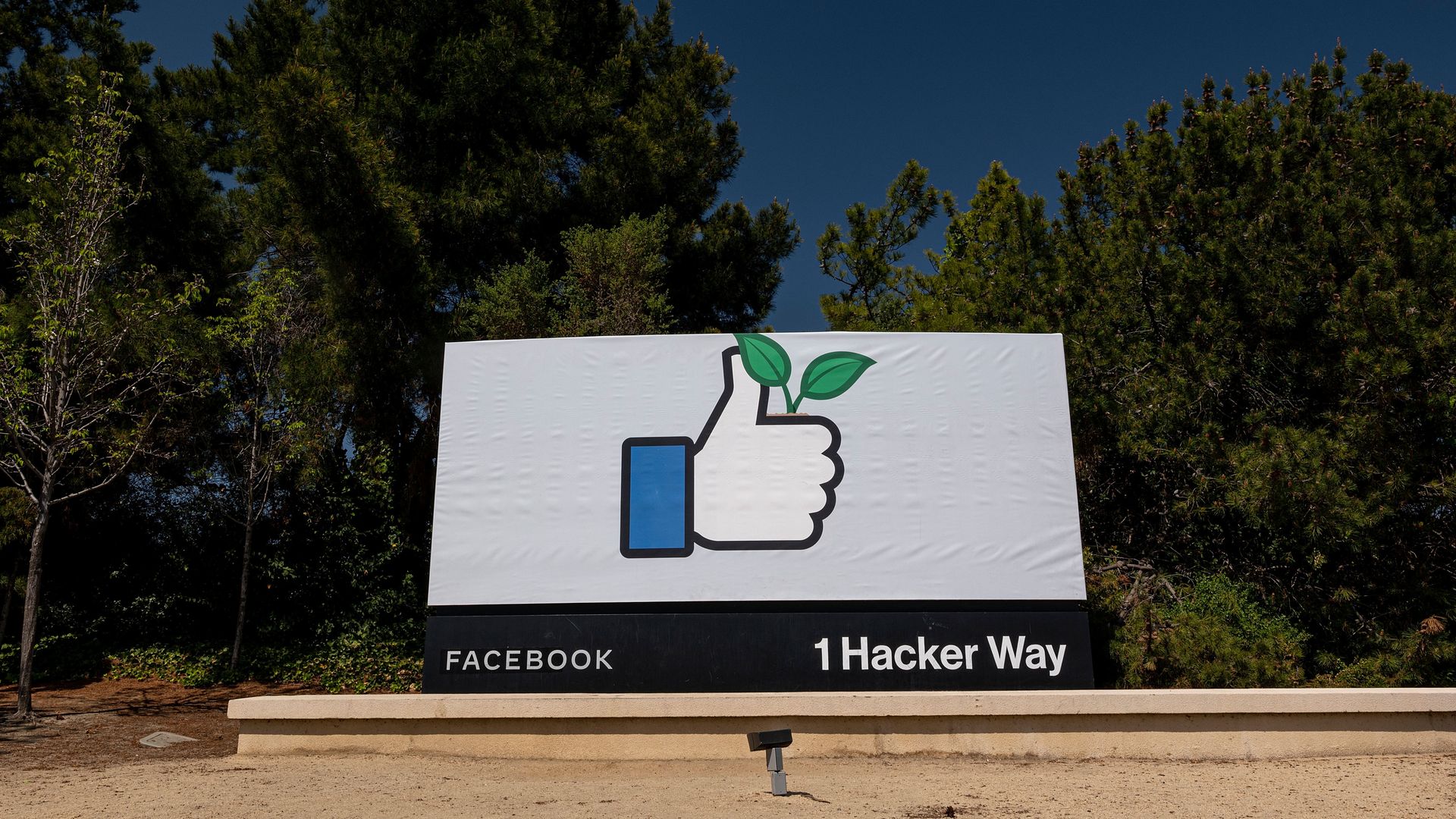 Photo of the main entrance of the Facebook headquarters, with a large sign that shows the Facebook thumbs up emoji