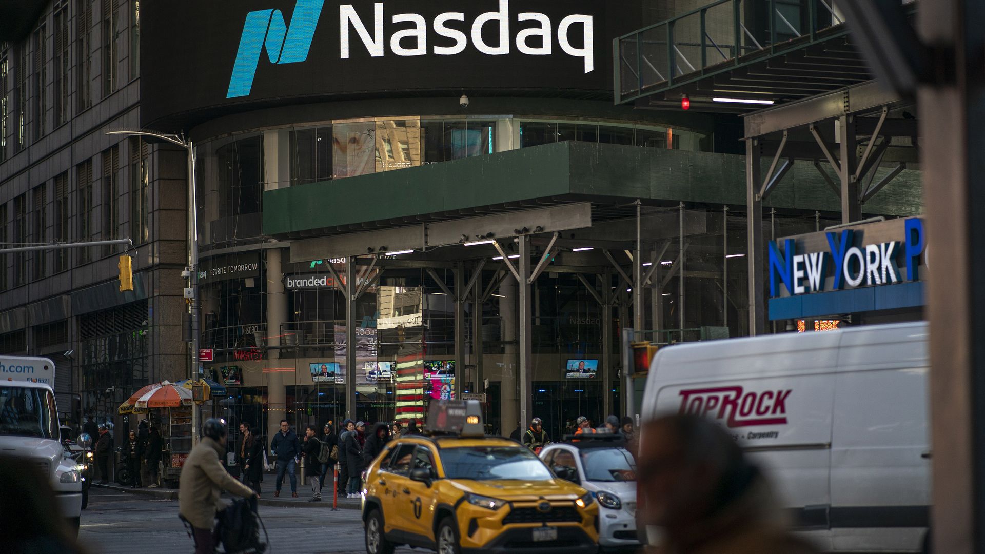 People walk near the Nasdaq building in Times Square on January 24, 2023. 