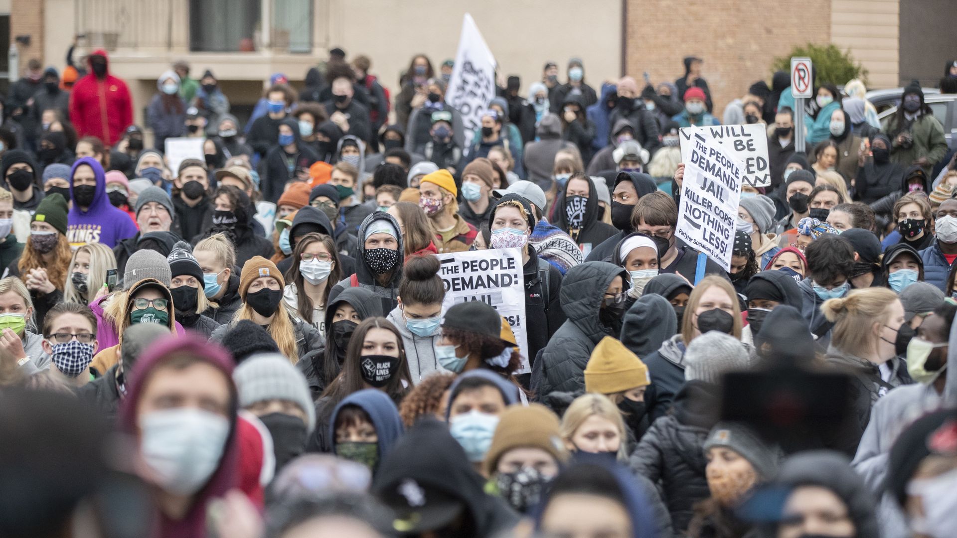 A crowd of people hold signs