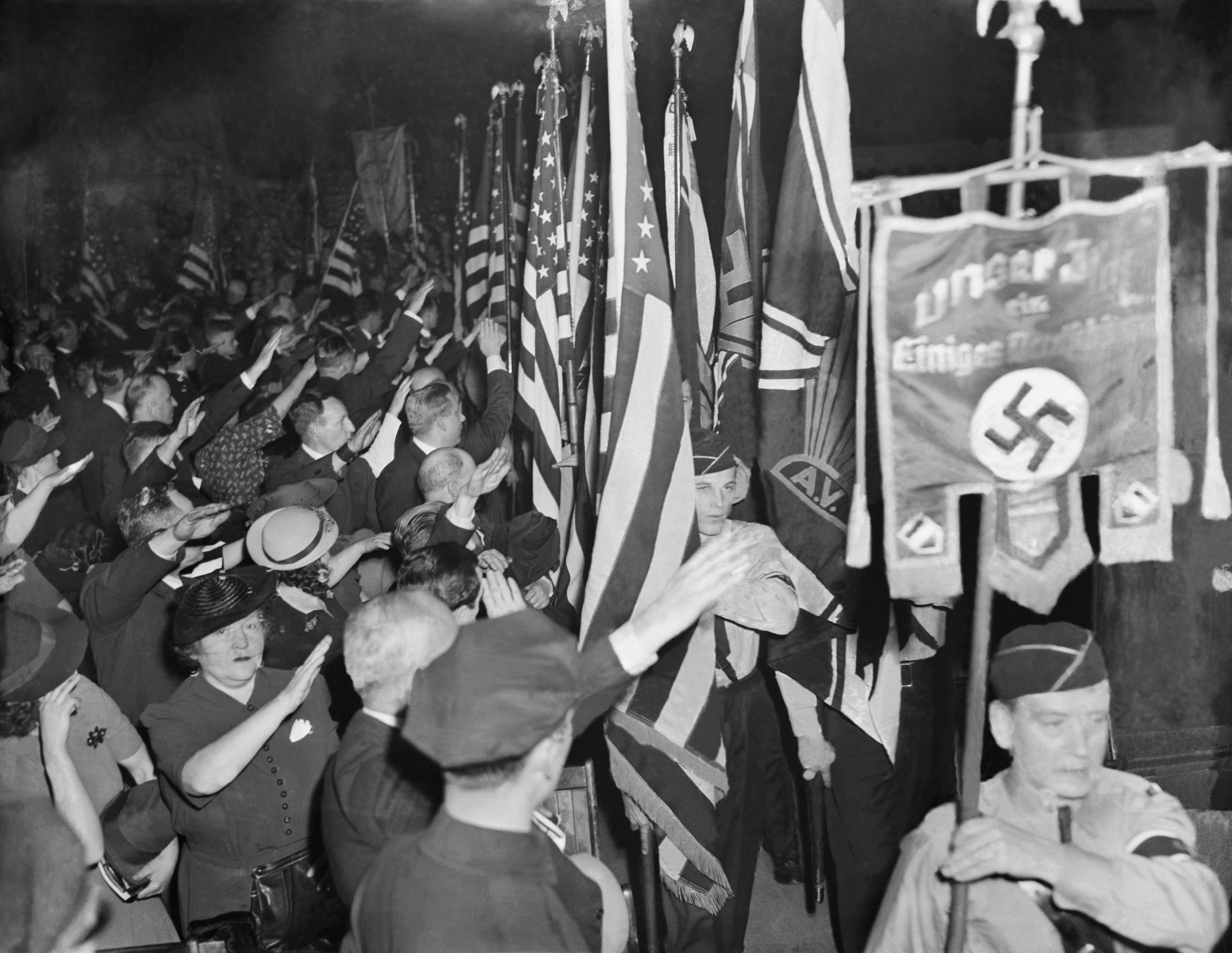 Snapping into the regulation Nazi salute, Bund members hail the swastika banner as it is paraded in Madison Square Garden during opening ceremonies of the German American Bund's Nazi "Pro-American Celebration of George Washington's Birthday." 