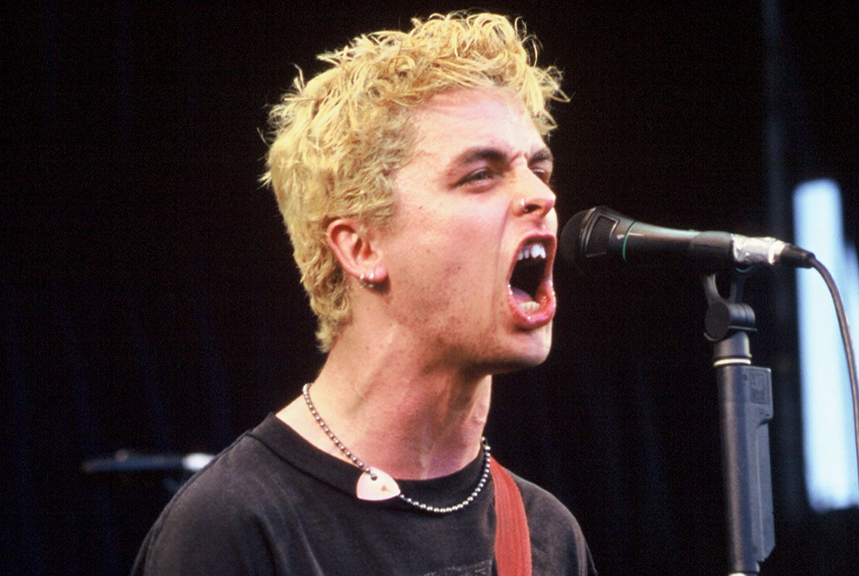 Green Day's Billie Joe Armstrong screams into a microphone circa 1994.