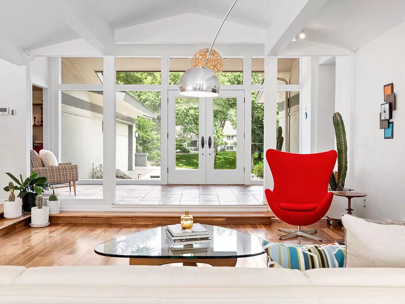 A house with floor-to-ceiling windows and red furniture.