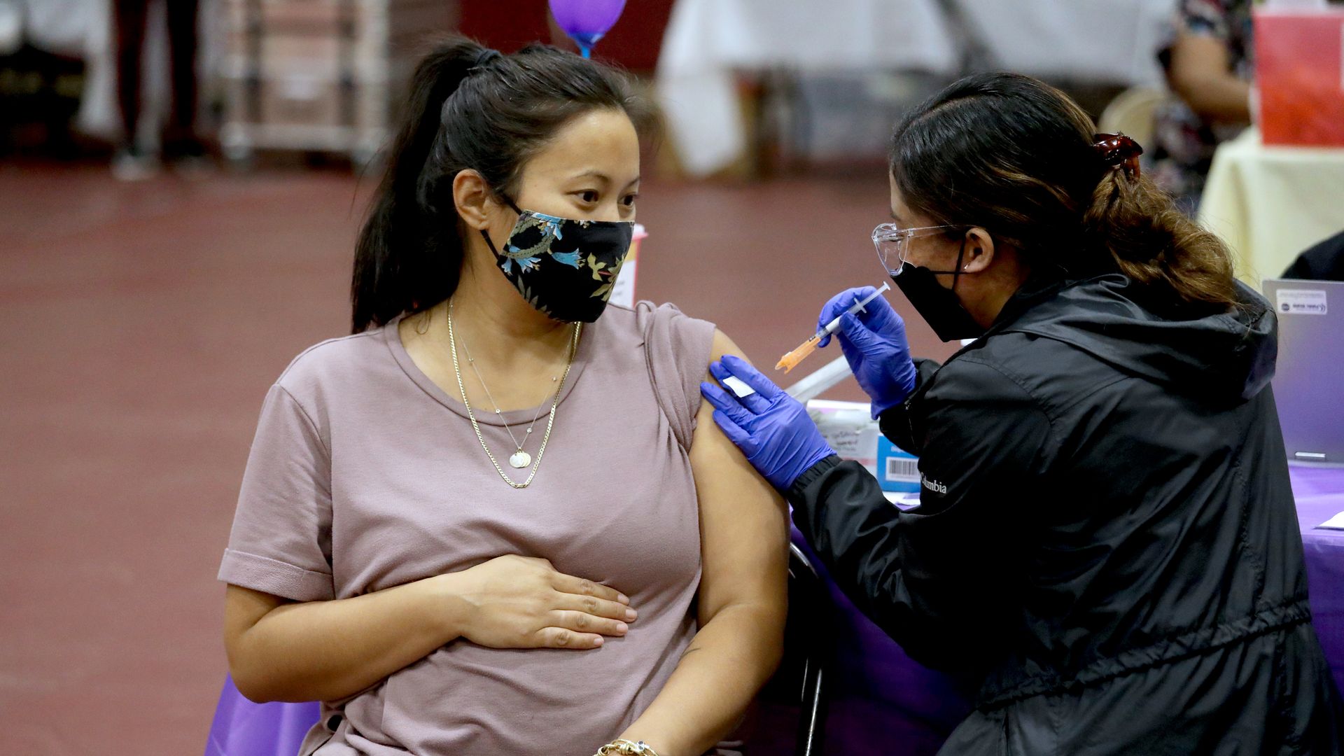 Picture of a pregnant person getting vaccinated