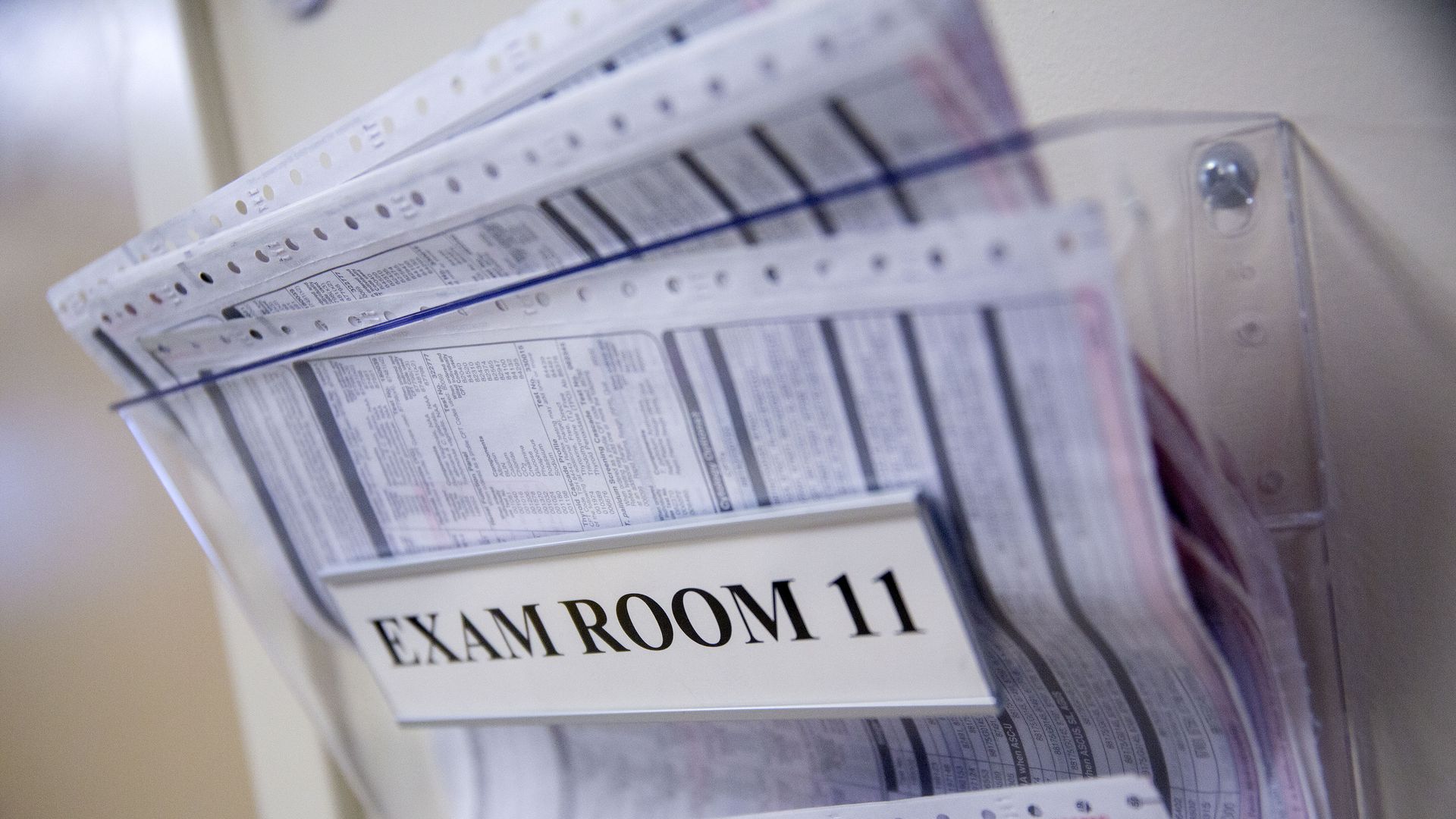 Medical forms sit outside an exam room at a clinic