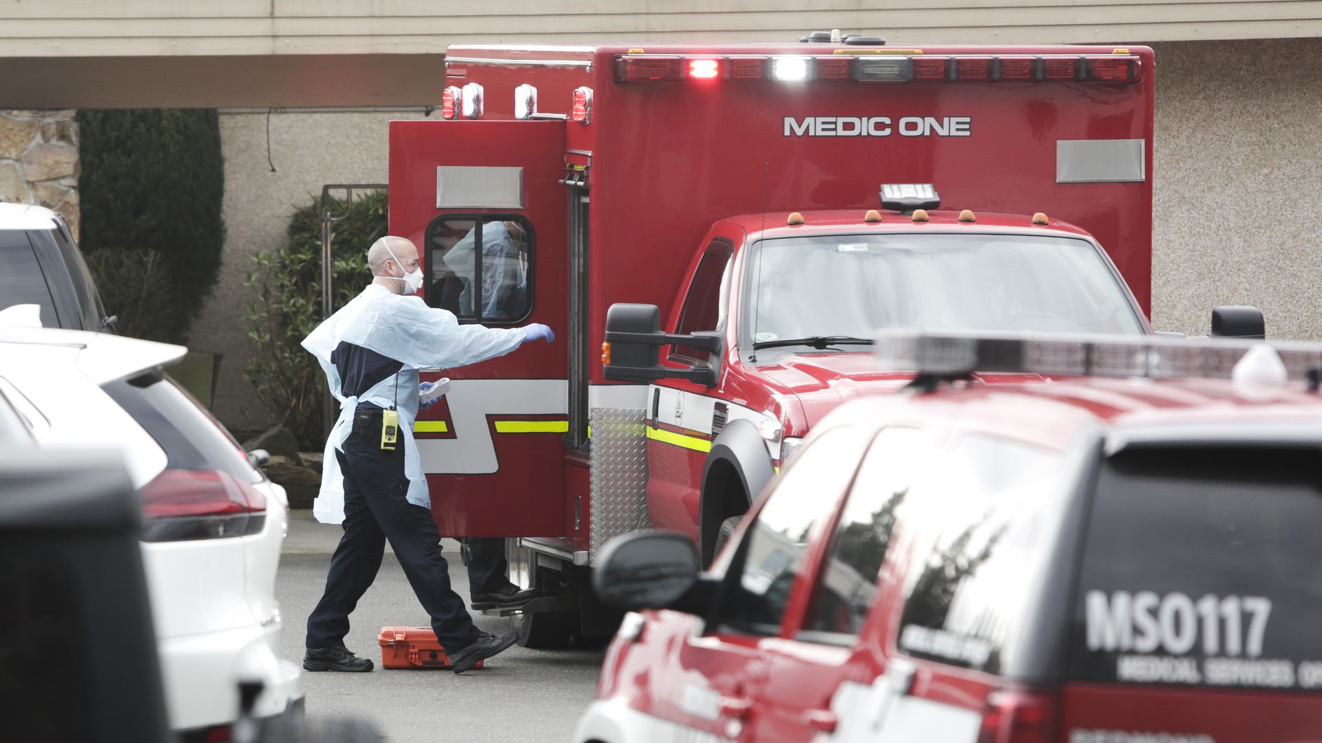Ambulance staff prepare to transport a patient from the Life Care Center nursing home