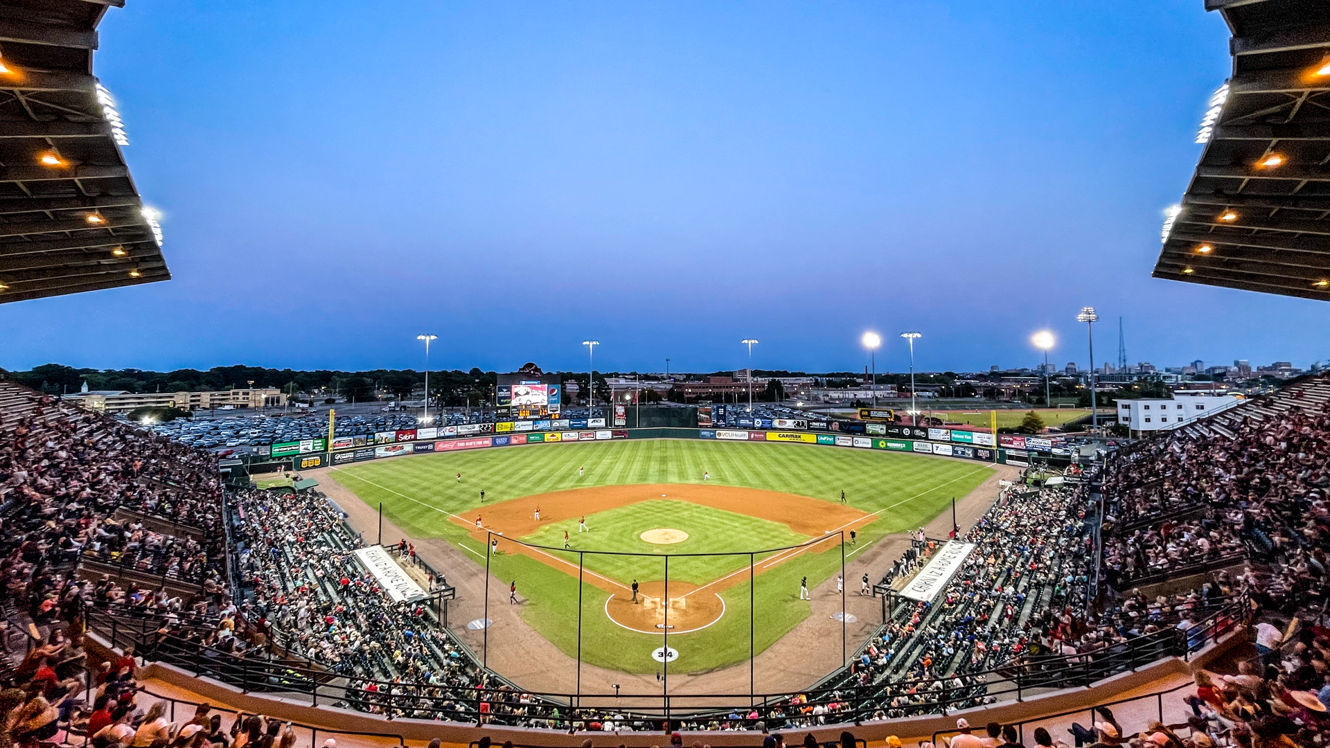 A baseball diamond with players on the field at night 