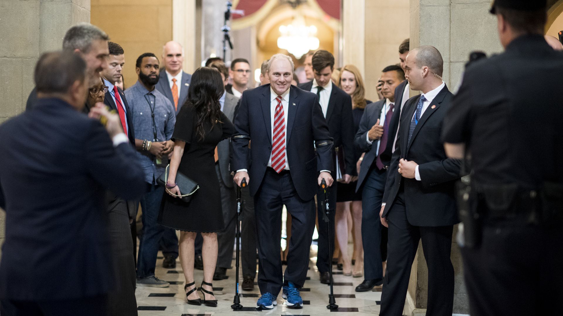 Steve Scalise uses two crutches to navigate a busy hallway.