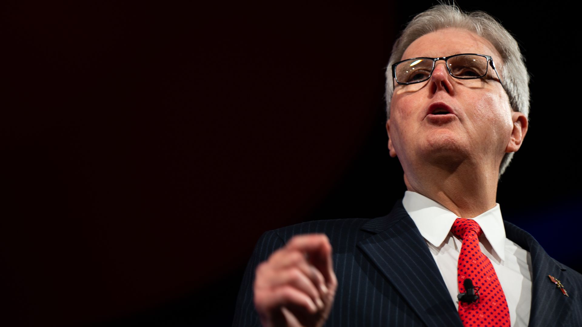 Lt. Gov Dan Patrick in a red tie, gesturing with his fingers