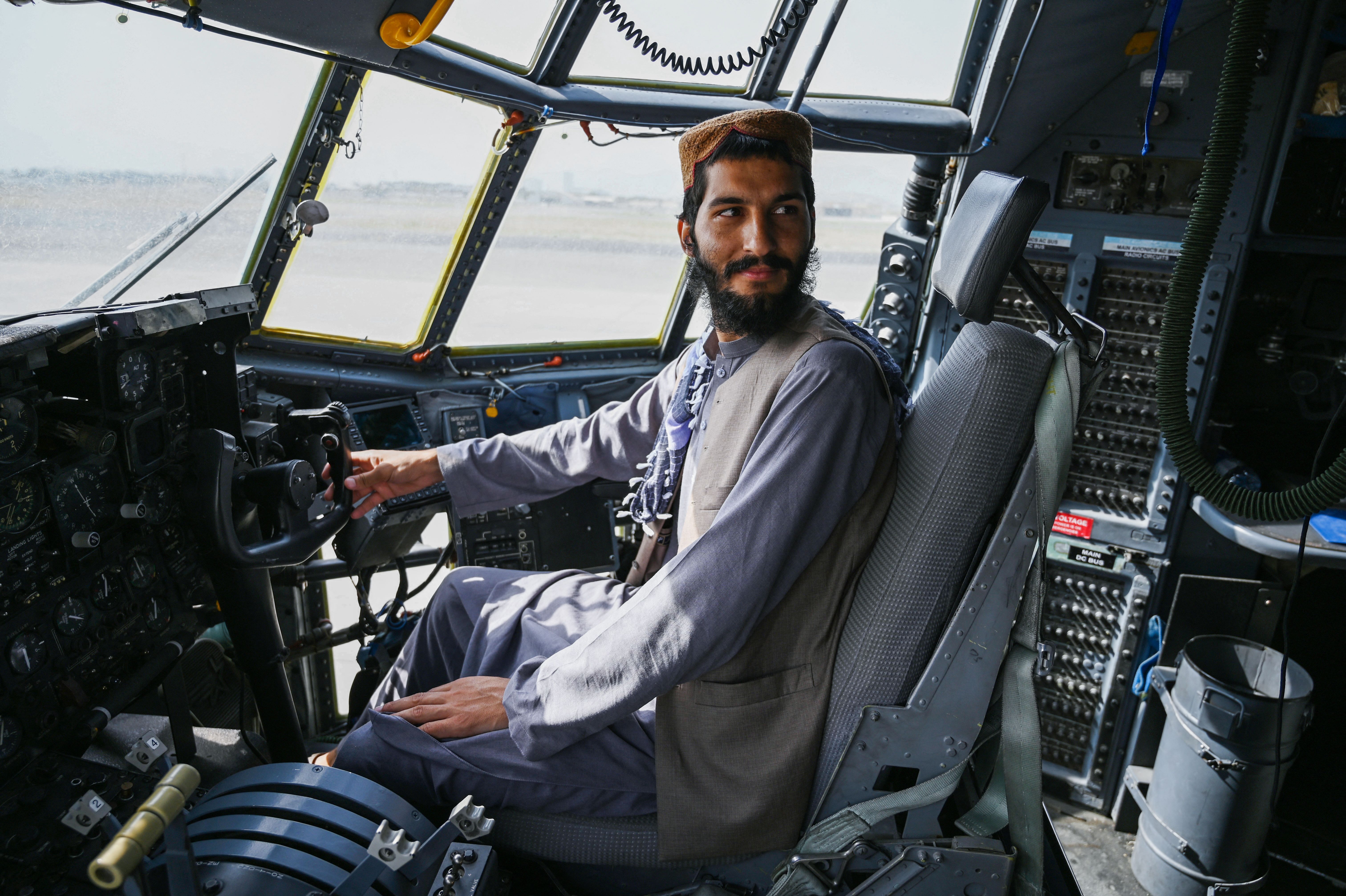  A Taliban fighter sits inside the cockpit of an Afghan Air Force aircraft at the airport in Kabul on August 31