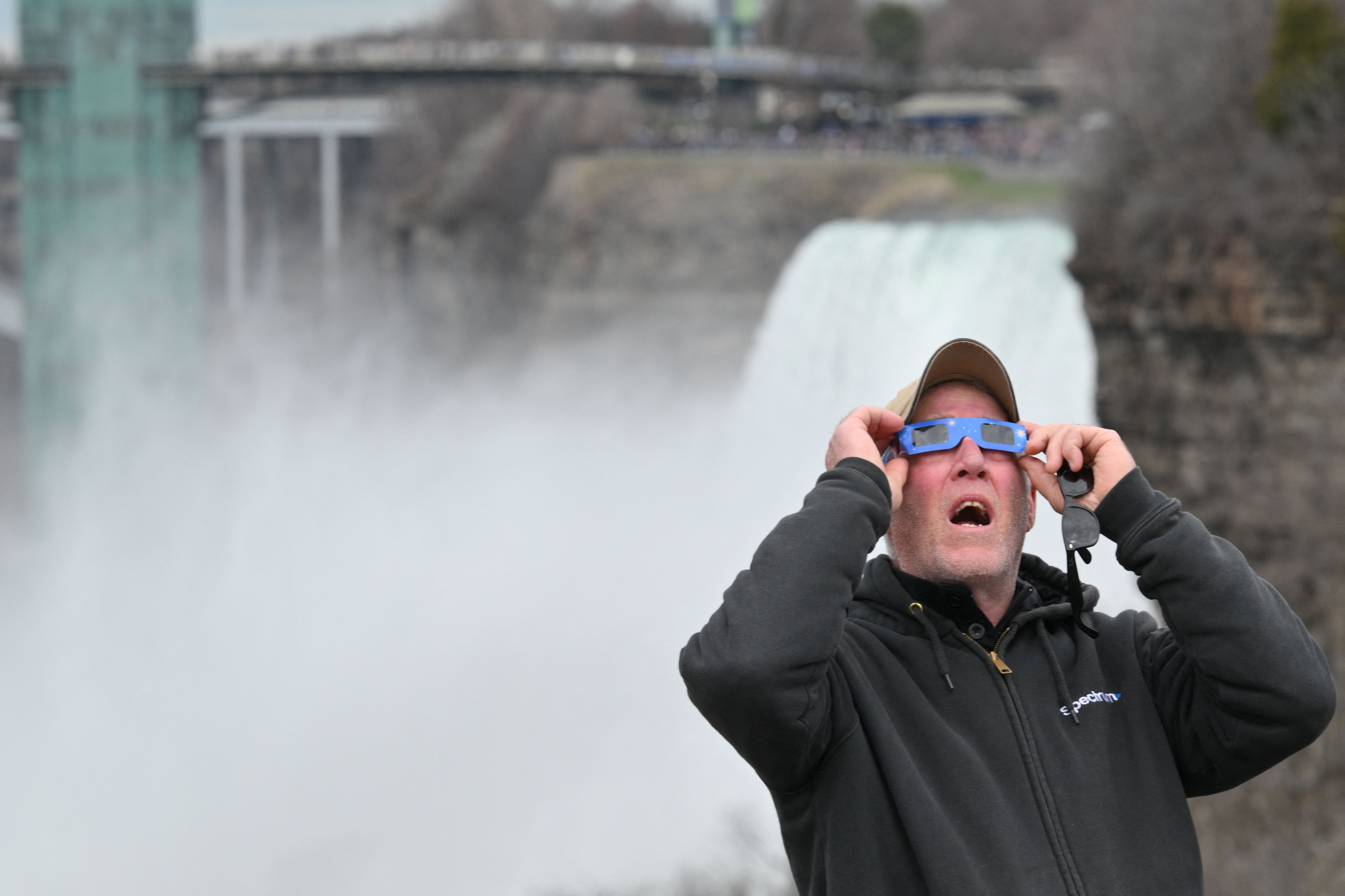 A man views the total solar eclipse at Niagara Falls State Park in Niagara Falls, New York, on April 8, 2024. This year's path of totality is 115 miles (185 kilometers) wide and home to nearly 32 million Americans, with an additional 150 million living less than 200 miles from the strip. The next total solar eclipse that can be seen from a large part of North America won't come around until 2044. (Photo by ANGELA WEISS / AFP) (Photo by ANGELA WEISS/AFP via Getty Images)