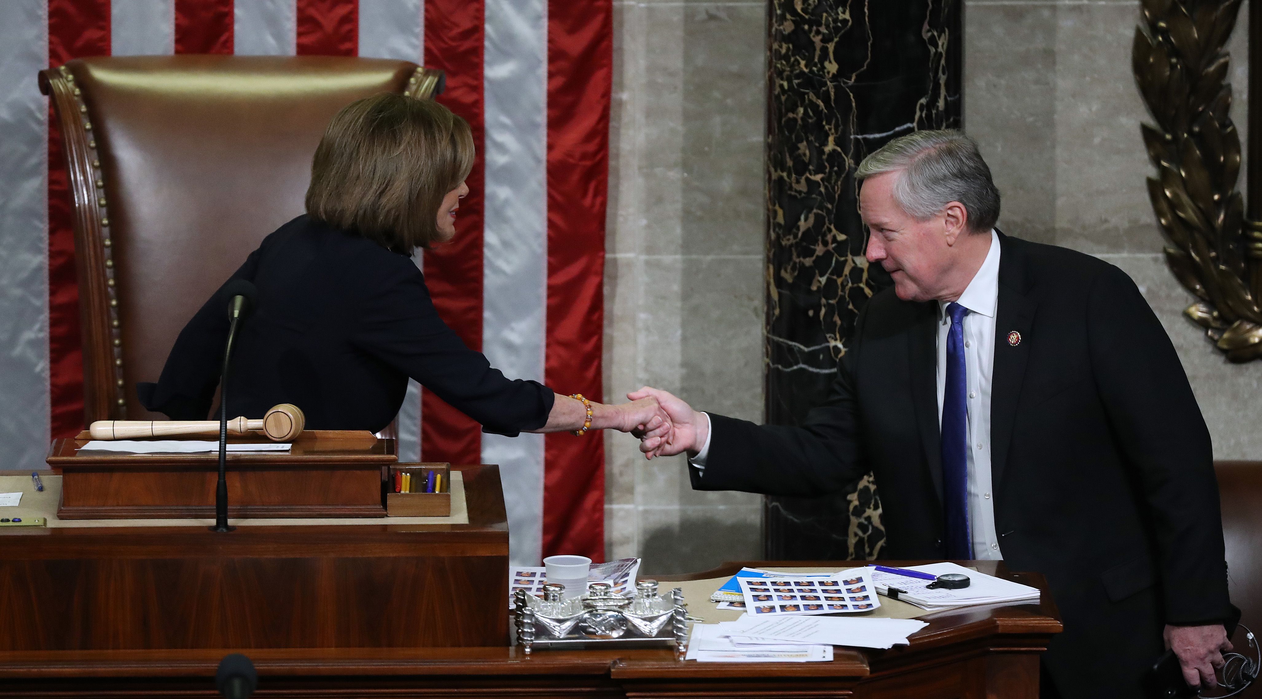 Speaker of the House Nancy Pelosi (D-CA) (L) shakes hand with Rep. Mark Meadows (R-NC) as she presides over the House of Representatives as they vote on the second article of impeachment 