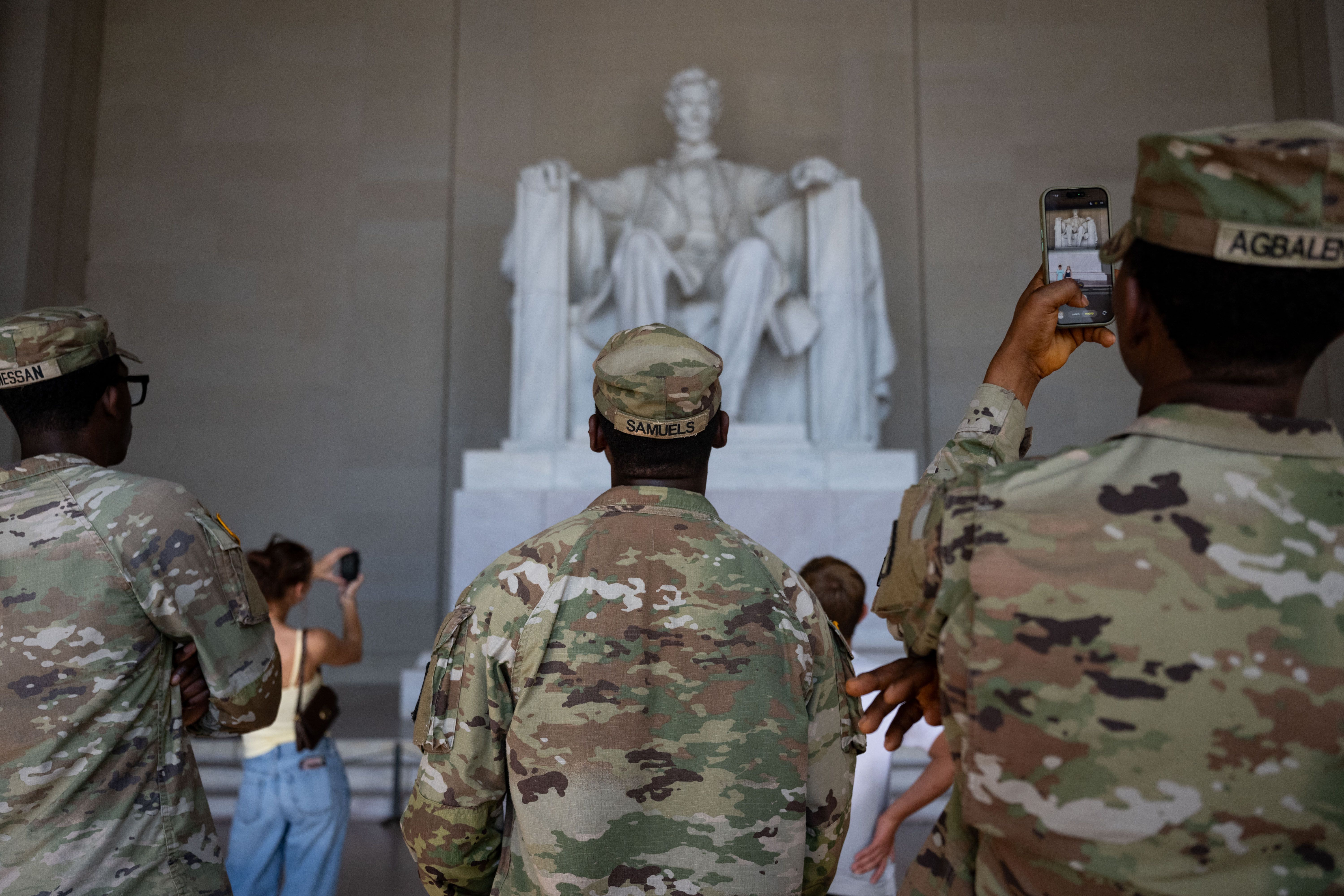 A view from behind National Guard members who are looking up at the Lincoln Memorial