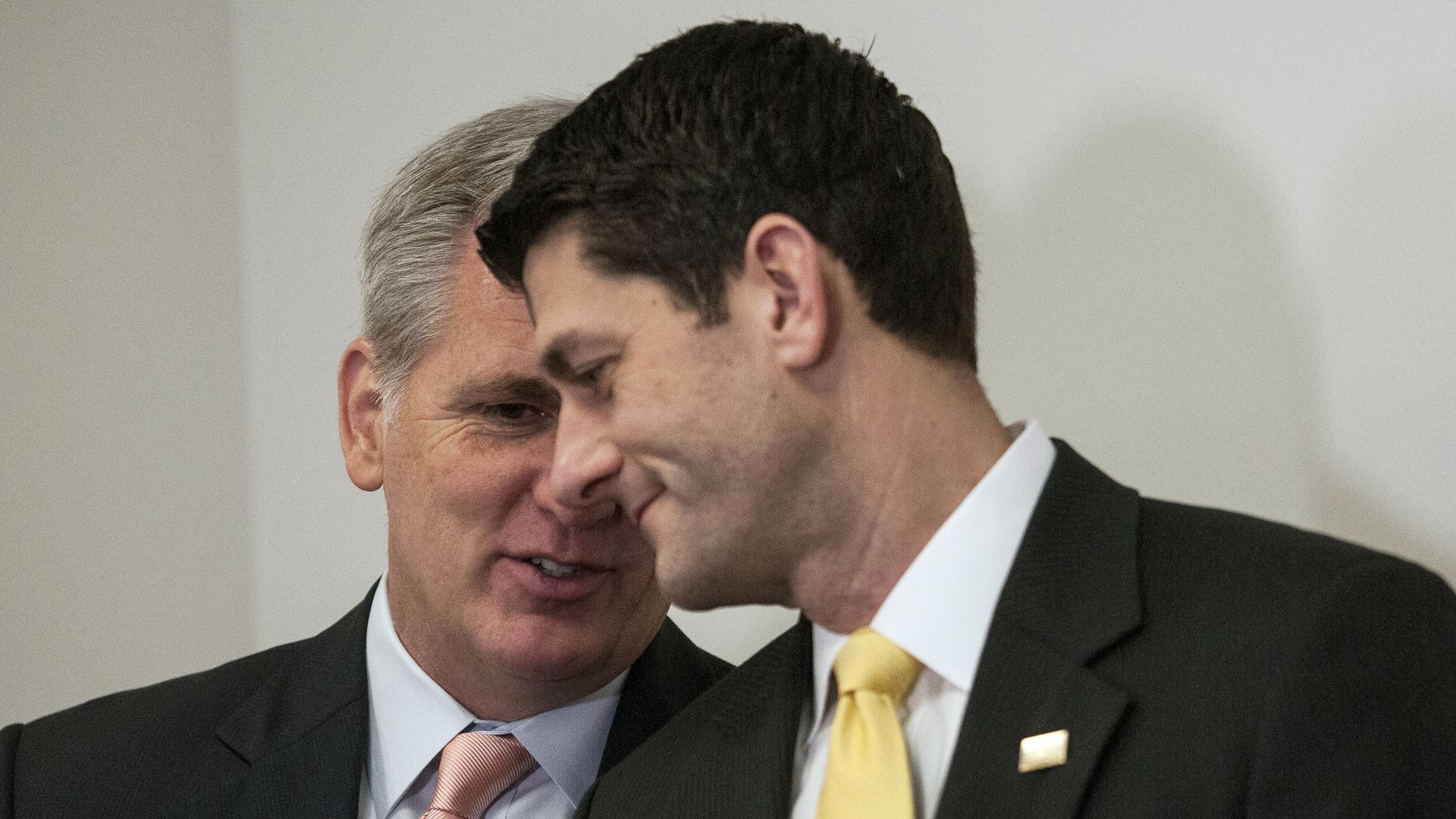 Paul Ryan leans over as Kevin McCarthy speaks in his ear.
