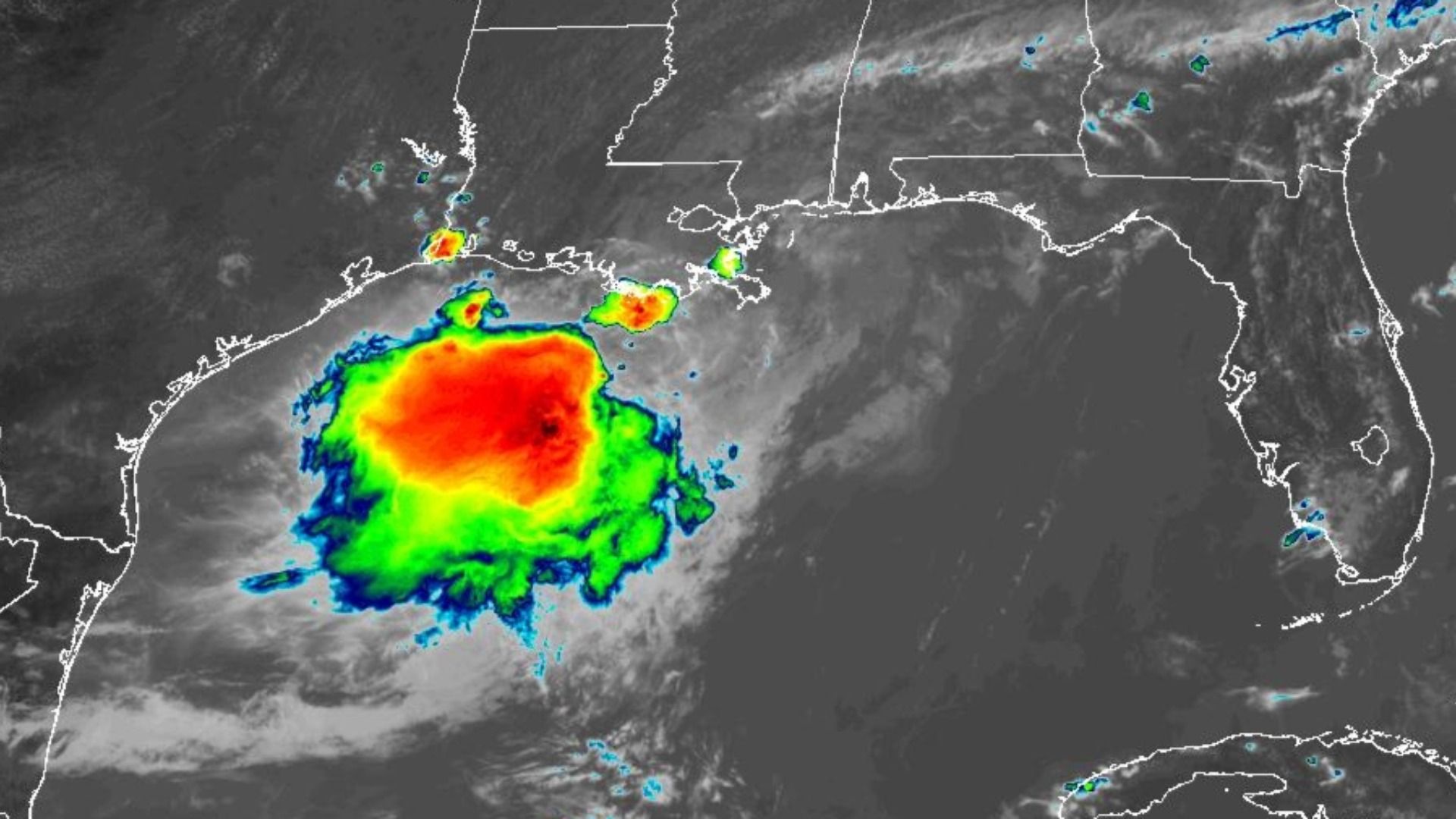 Infrared satellite image shows a large tropical storm in the Gulf of Mexico with a red-orange core; white coastlines mark Florida, Alabama, Mississippi, and Louisiana against gray skies.