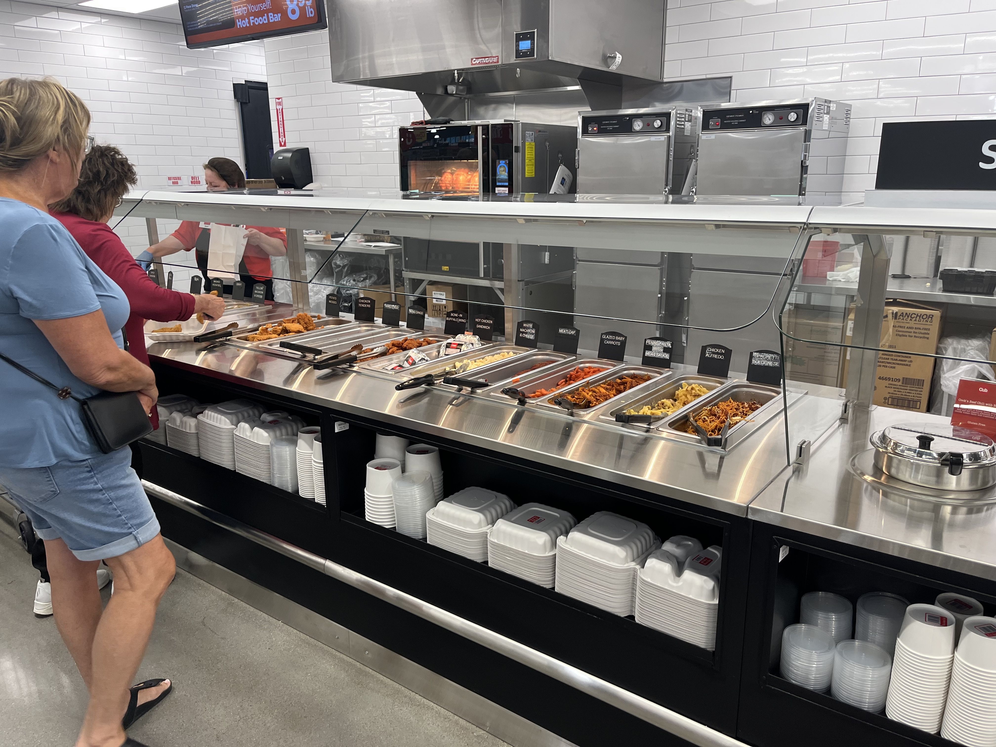 A photo of a woman looking at the deli bar 