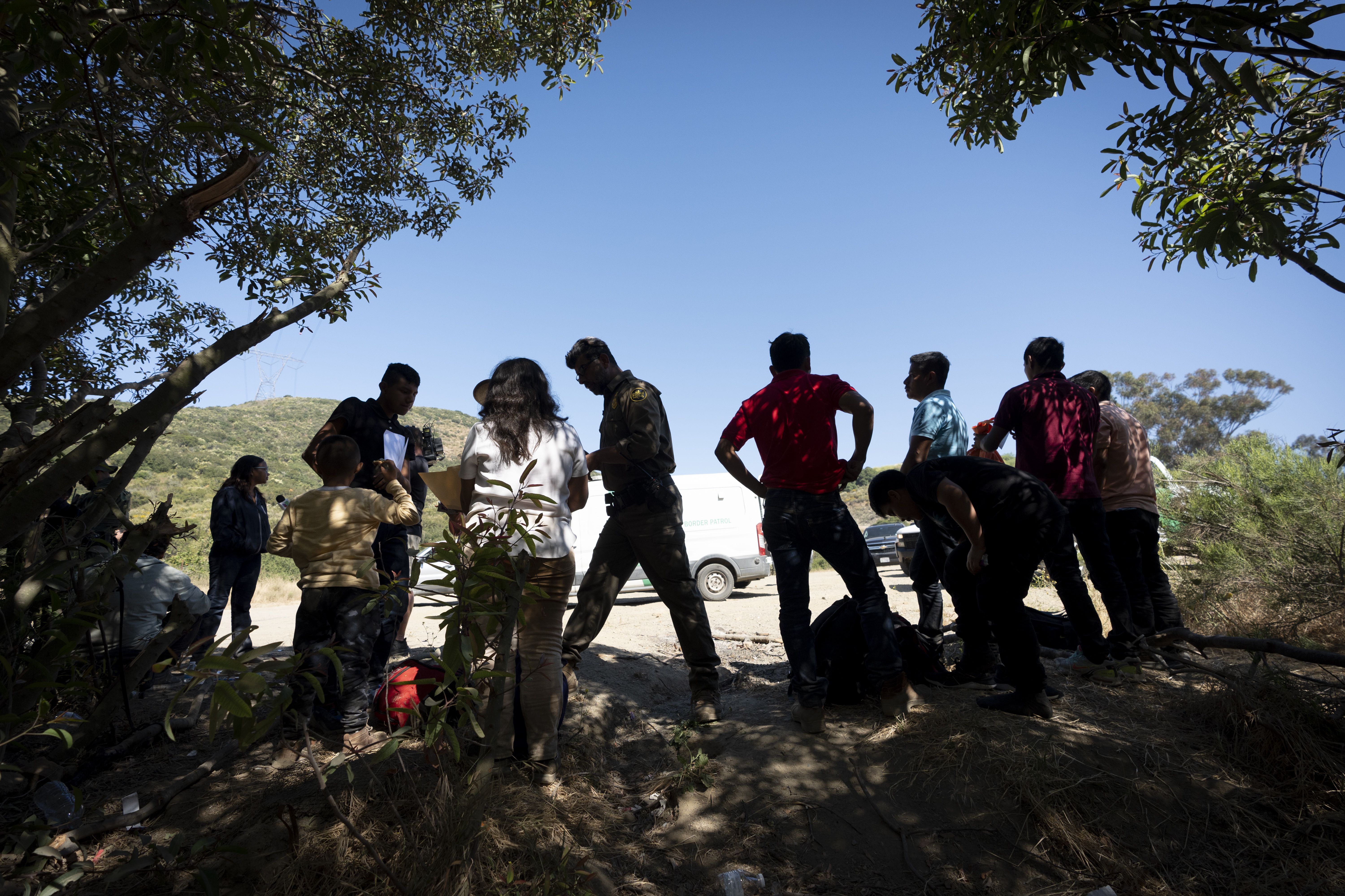 Border Patrol agents talk with migrants seeking asylum near Dulzura, Calif., last Wednesday.