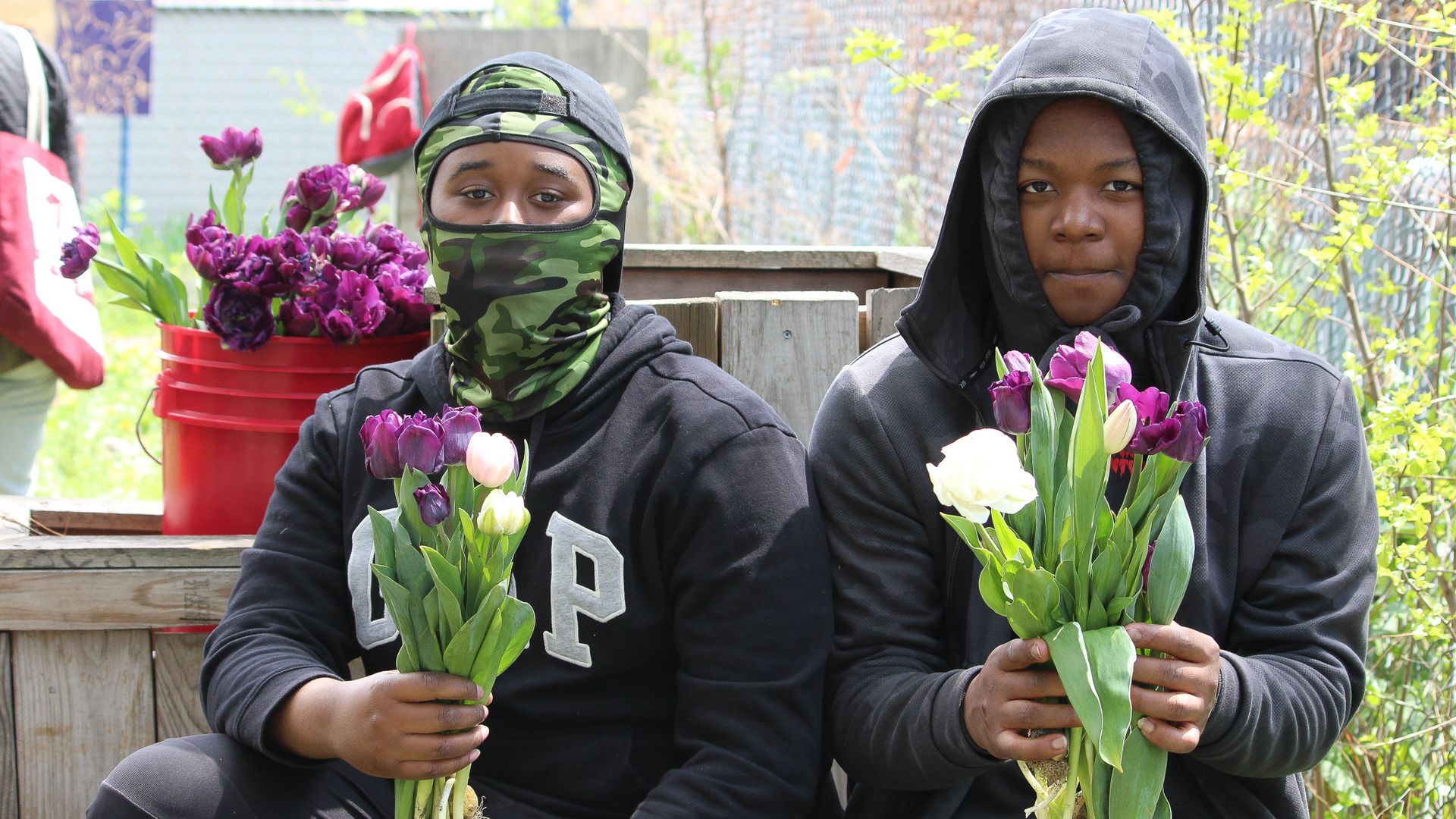 A photo of two people holding flowers. 