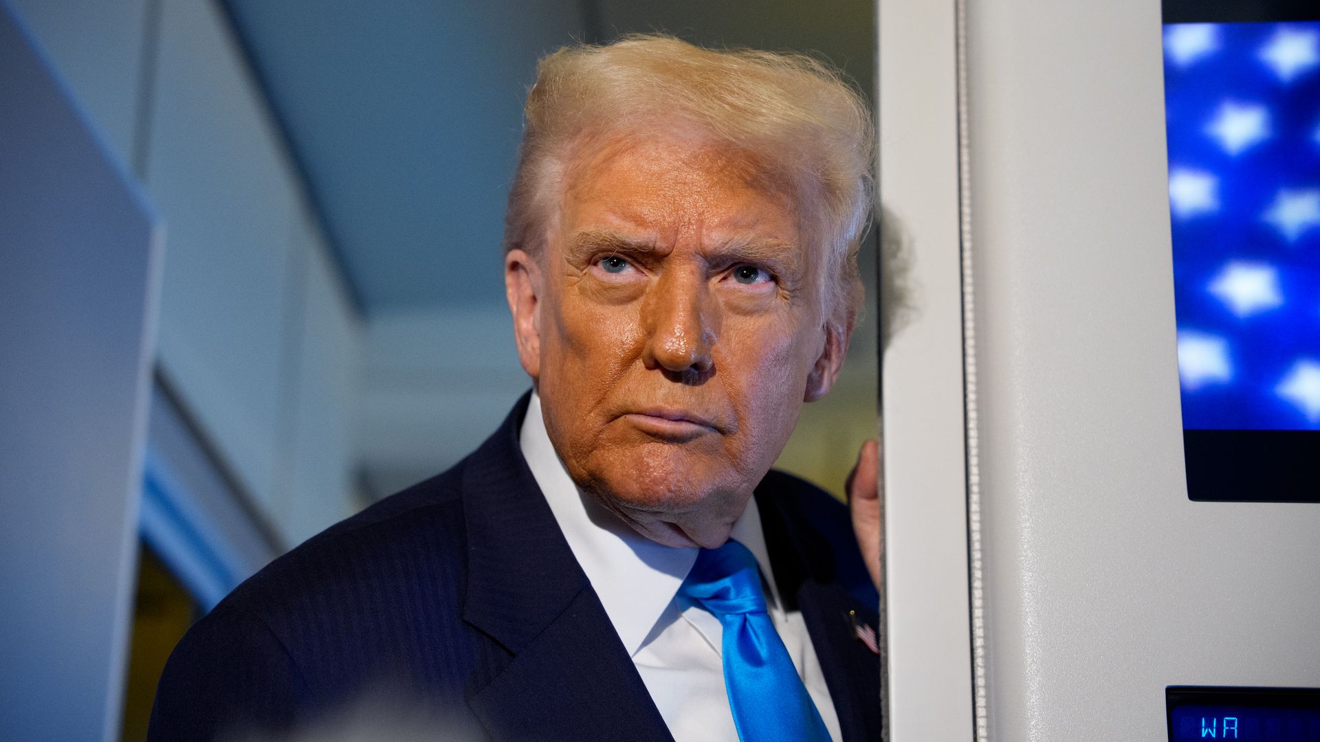 President Trump speaks to journalists aboard Air Force One.
