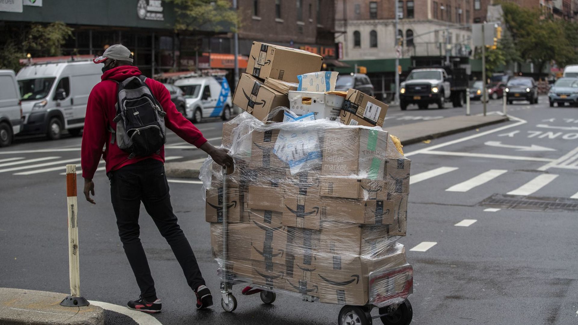 A worker wheels a cart of Amazon packages during a delivery in New York in October. 