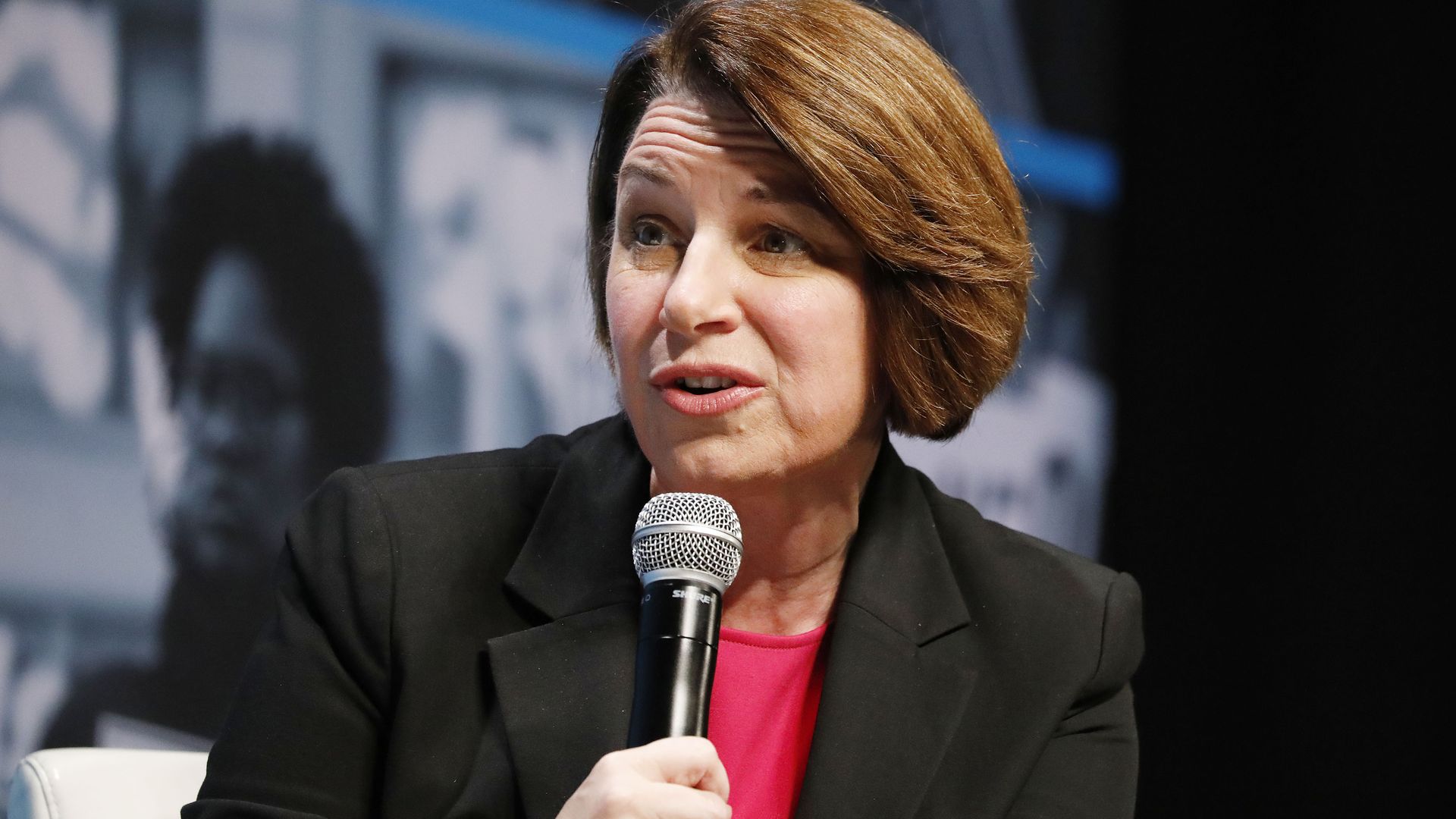 Klobuchar speaking into a microphone. 