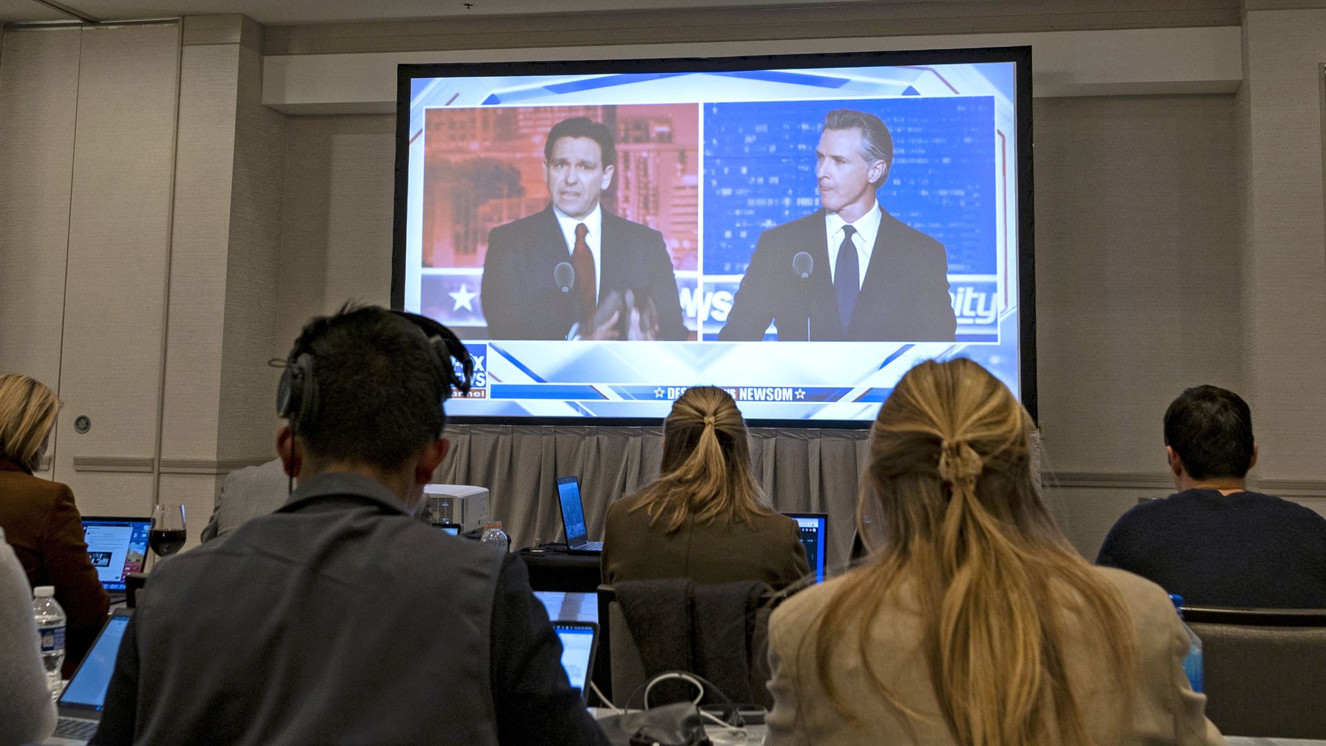 Florida Governor and Republican presidential hopeful Ron DeSantis (L) and California Governor Gavin Newsom (R) appear on screen from the press room during a debate held by Fox News, in Alpharetta, Georgia, on November 30, 2023.