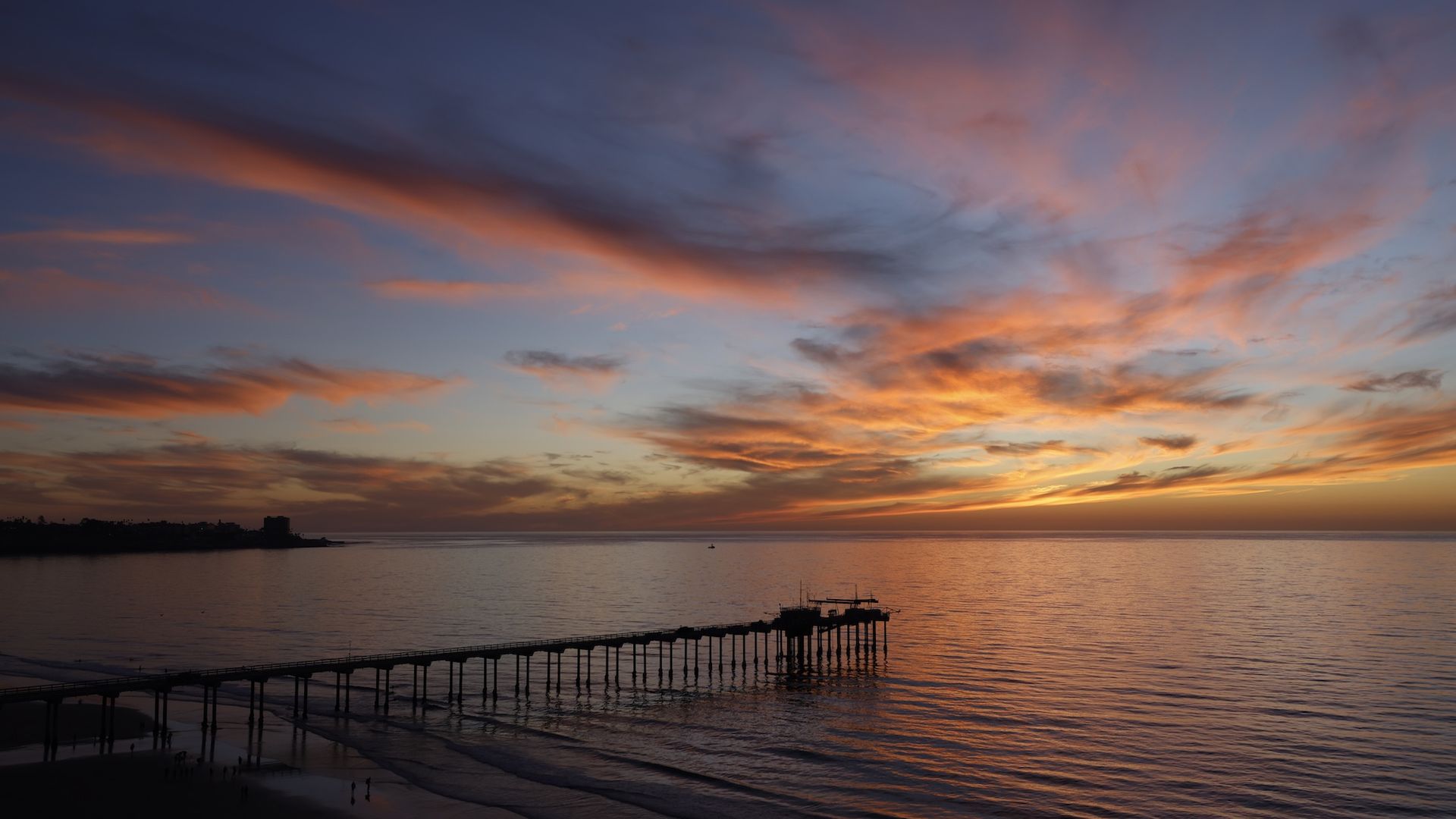 A vibrant sunset behind a pier.