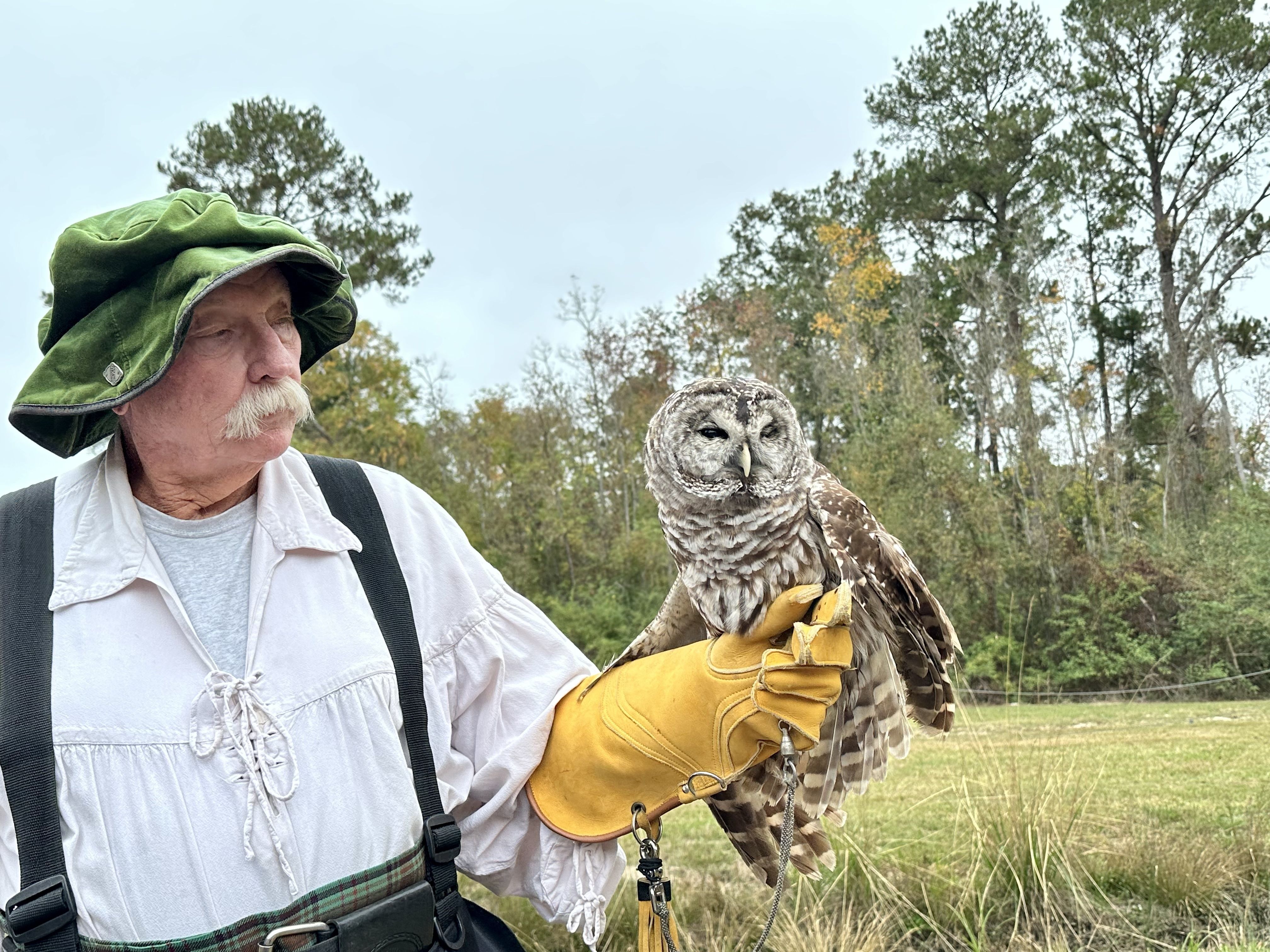 Photo shows a man with an owl.