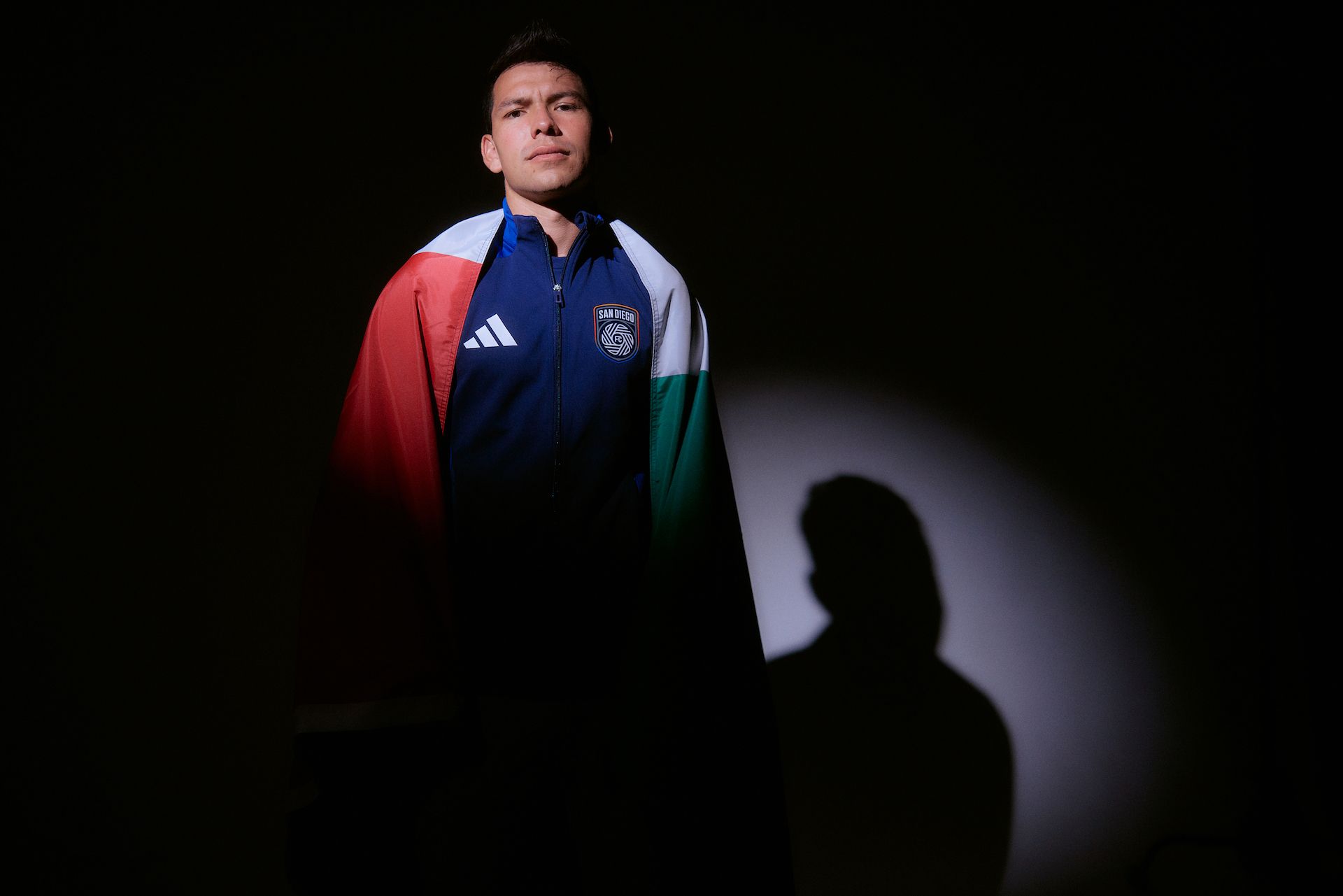 Chucky Lozano with a Mexican flag draped over his shoulders.
