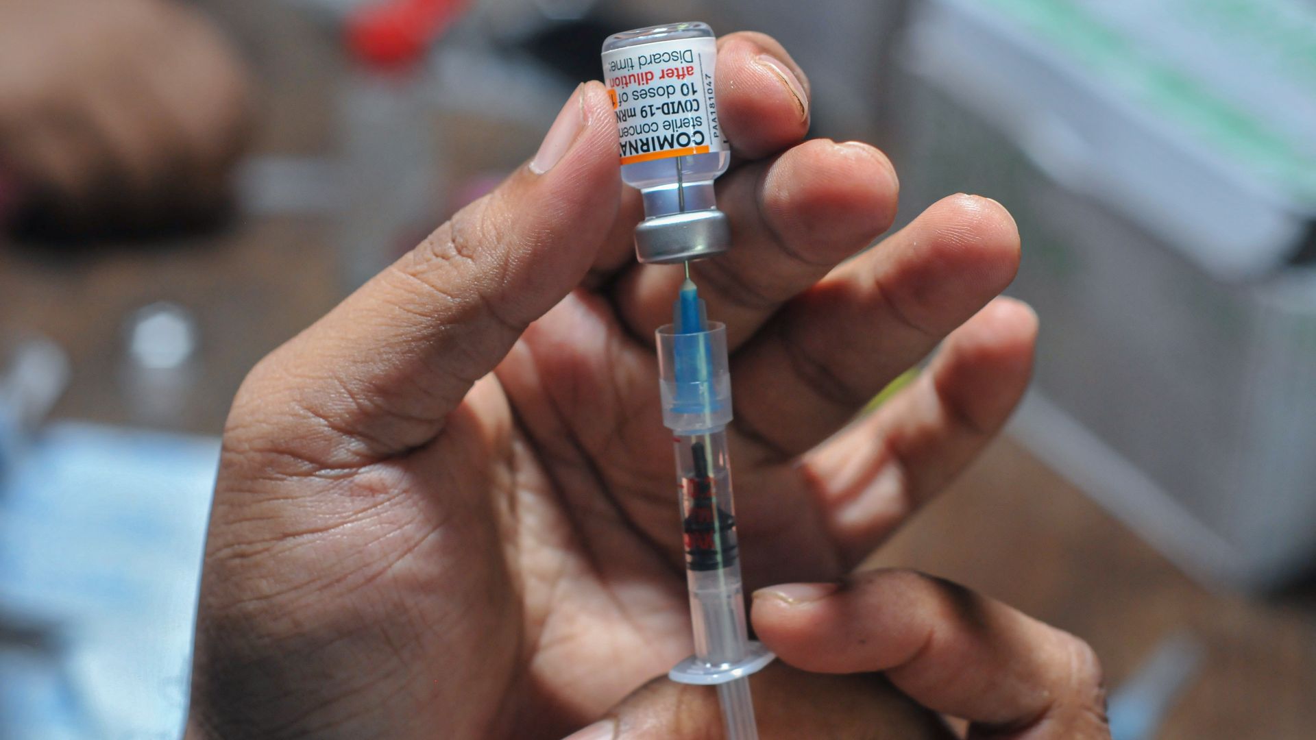 A health worker prepares a dose of Pfizer COVID-19 vaccine.