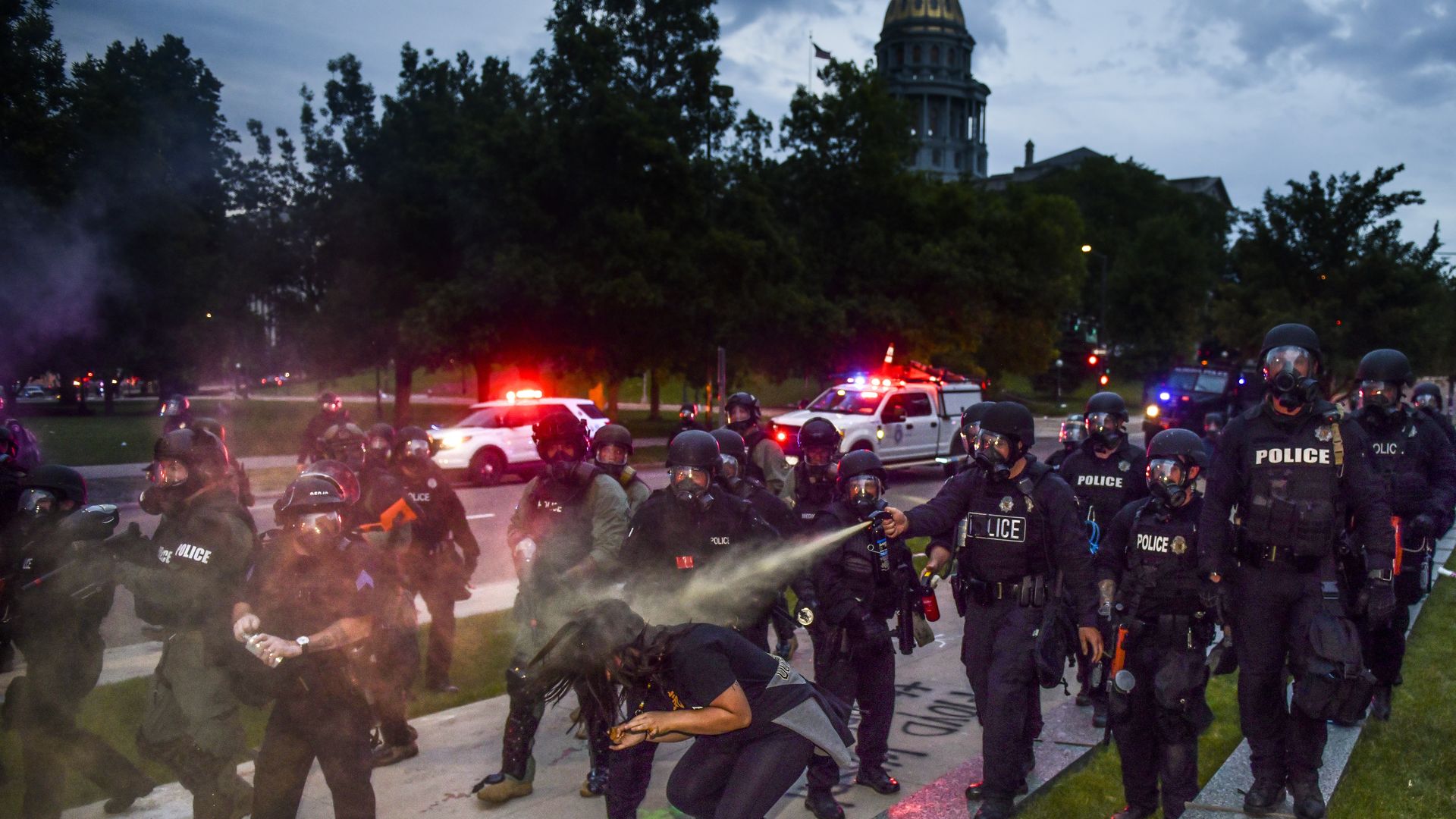 A photo of police officers pepper spraying a protester last May in Denver