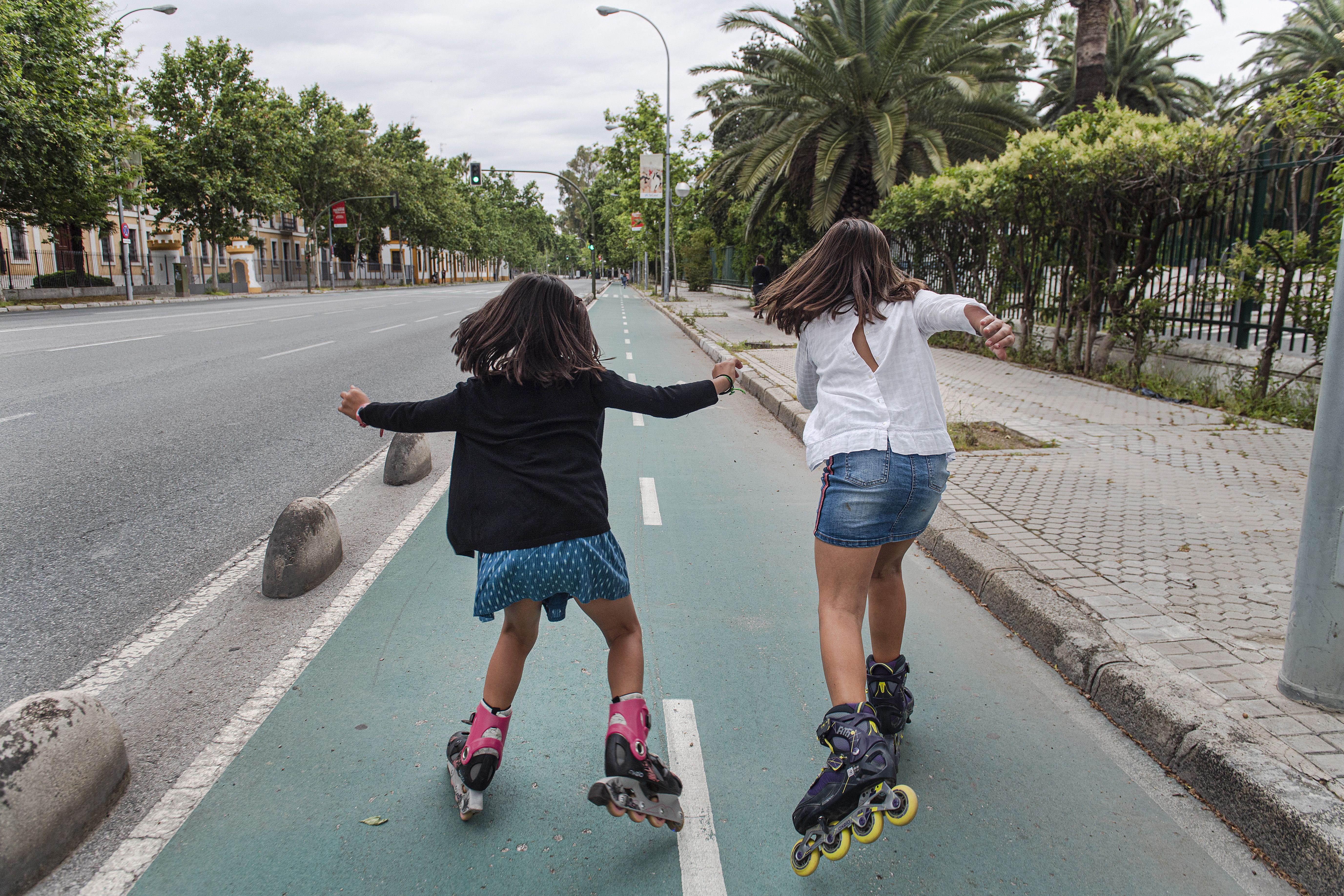 In this image, two girls rollerskate together