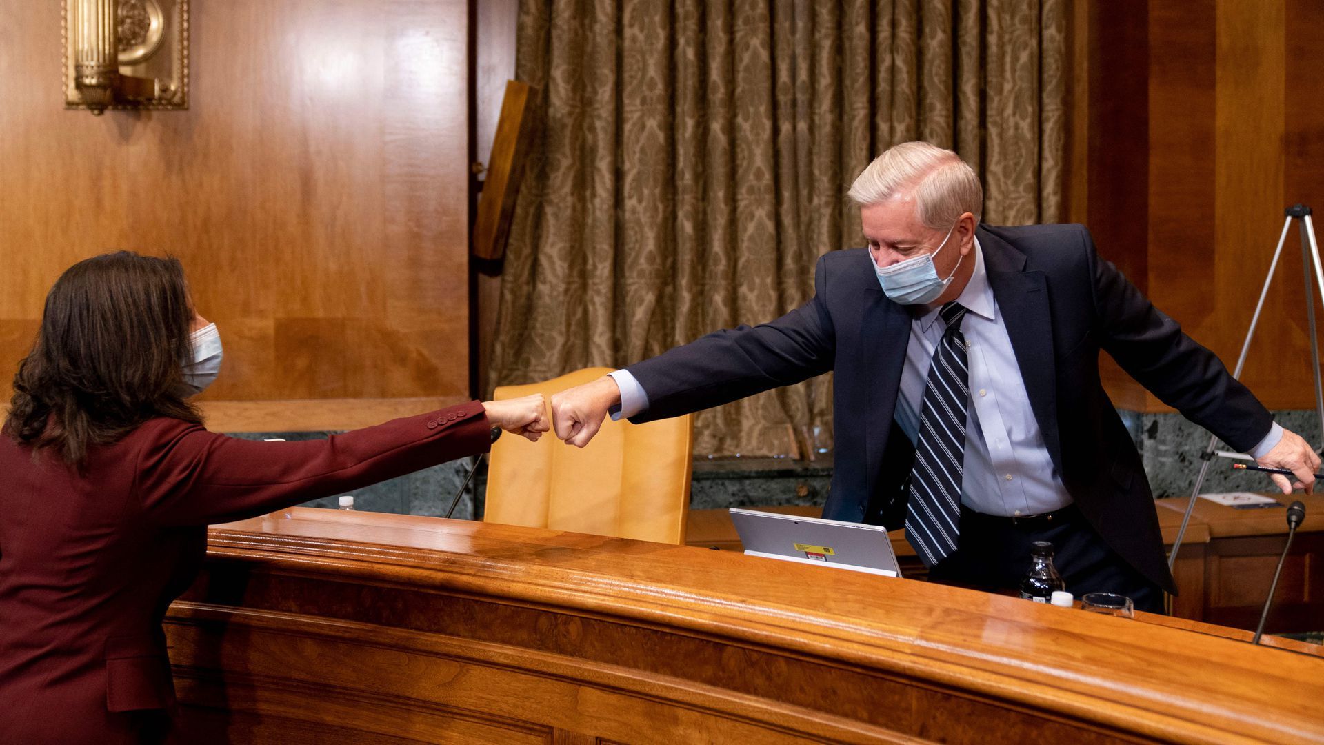 Neera Tanden greets Sen. Lindsey Graham, top Republican on the Senate Budget Committee, before a hearing Feb. 10.