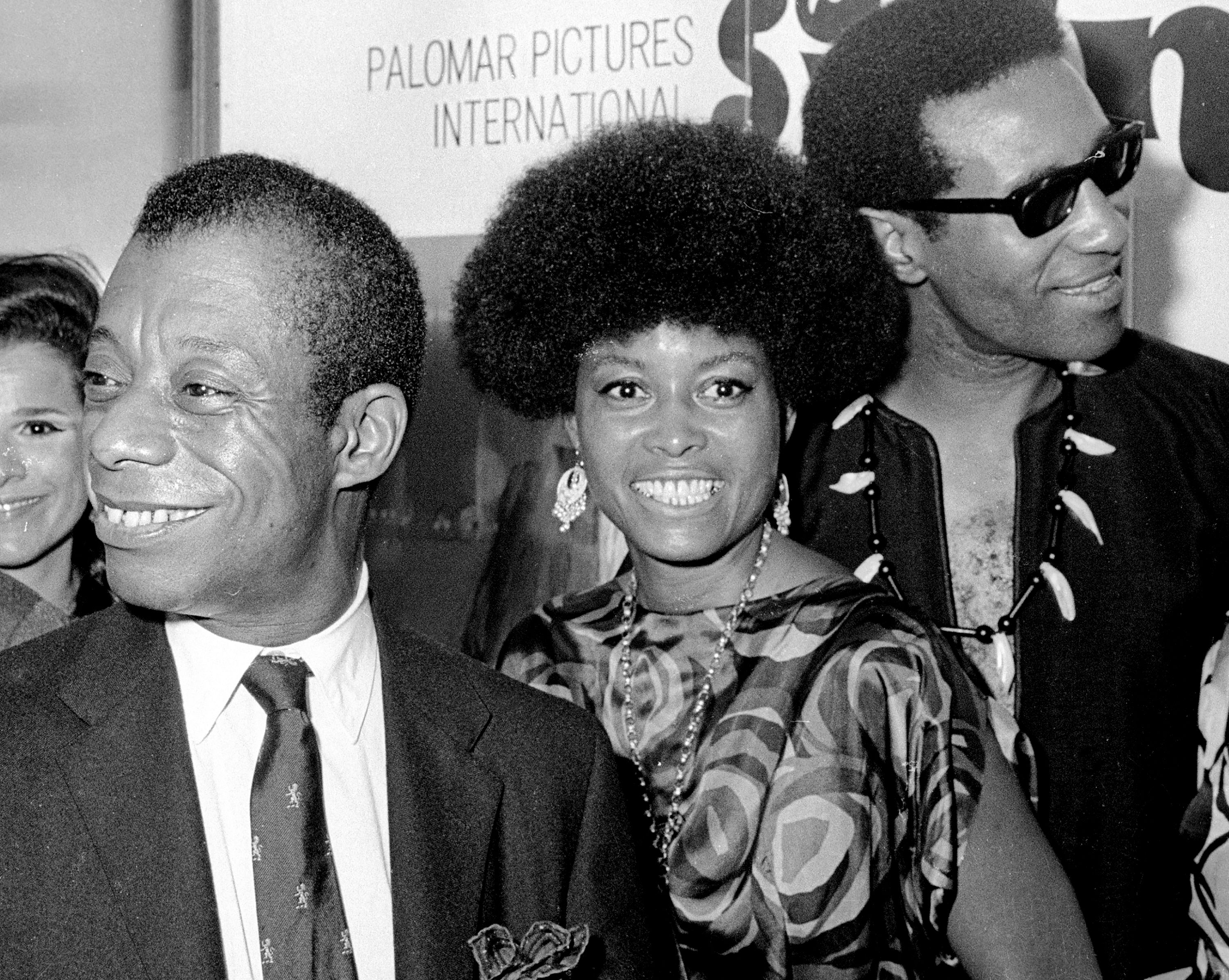 James Baldwin, Jazz vocalist Abbey Lincoln, and Jazz musician Max Roach attend a premiere of 'For Love of Ivy' at Loew's Tower East Theater, New York, July 16, 1968. 