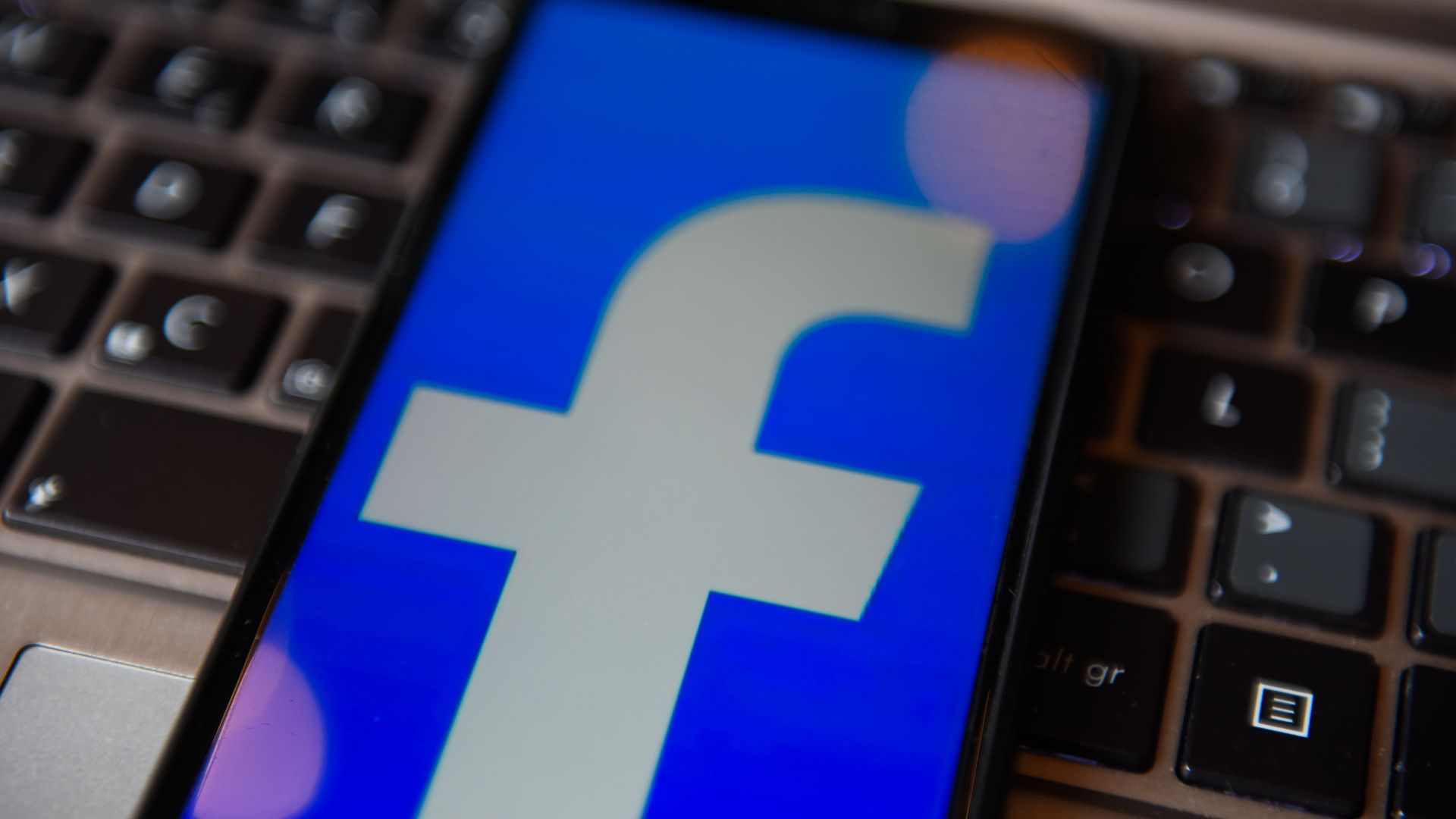 A photo of the Facebook logo displayed on a smartphone screen