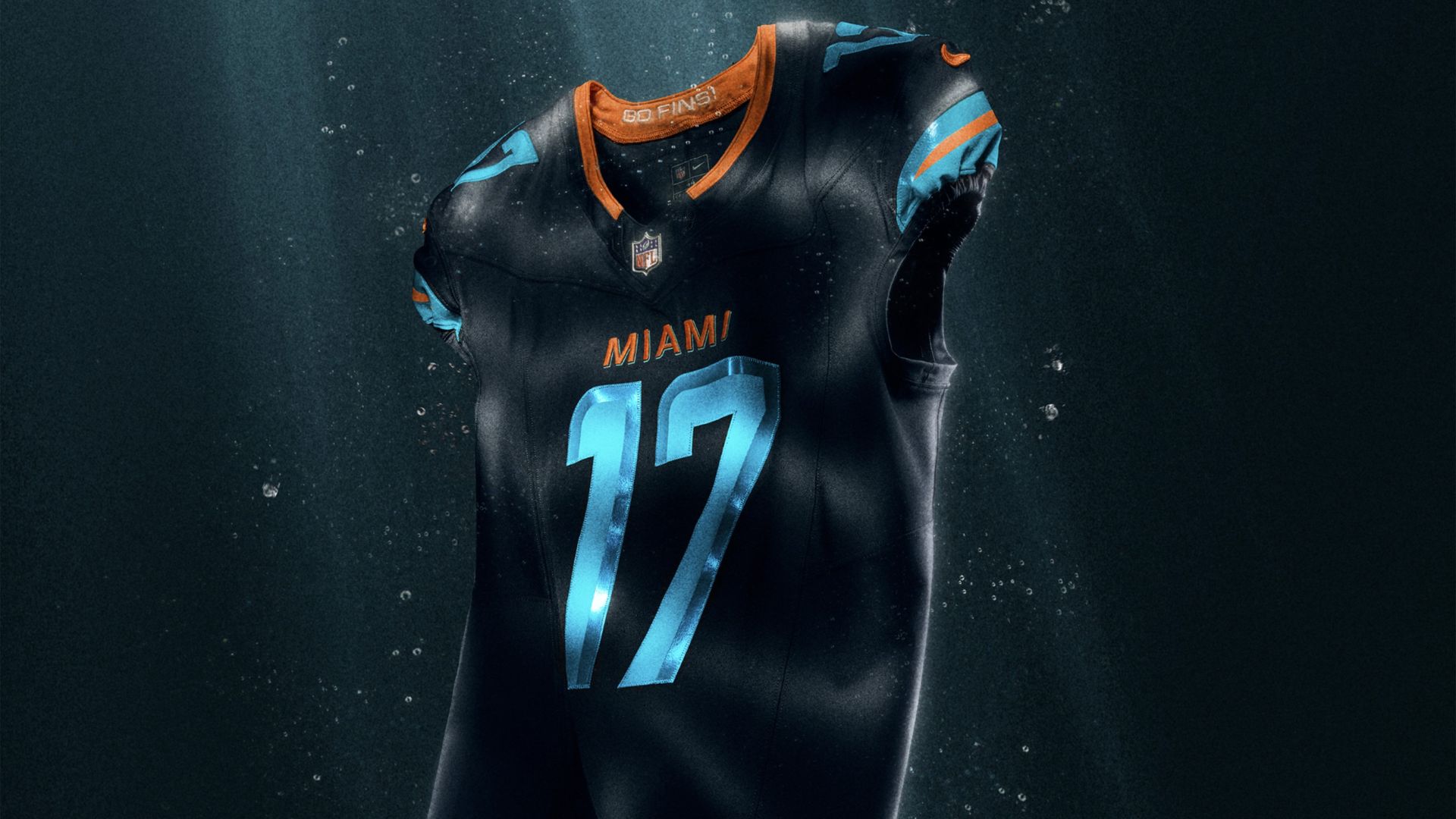 Dark Miami football jersey with light blue number 17 and orange accents, floating underwater with light rays penetrating from above.