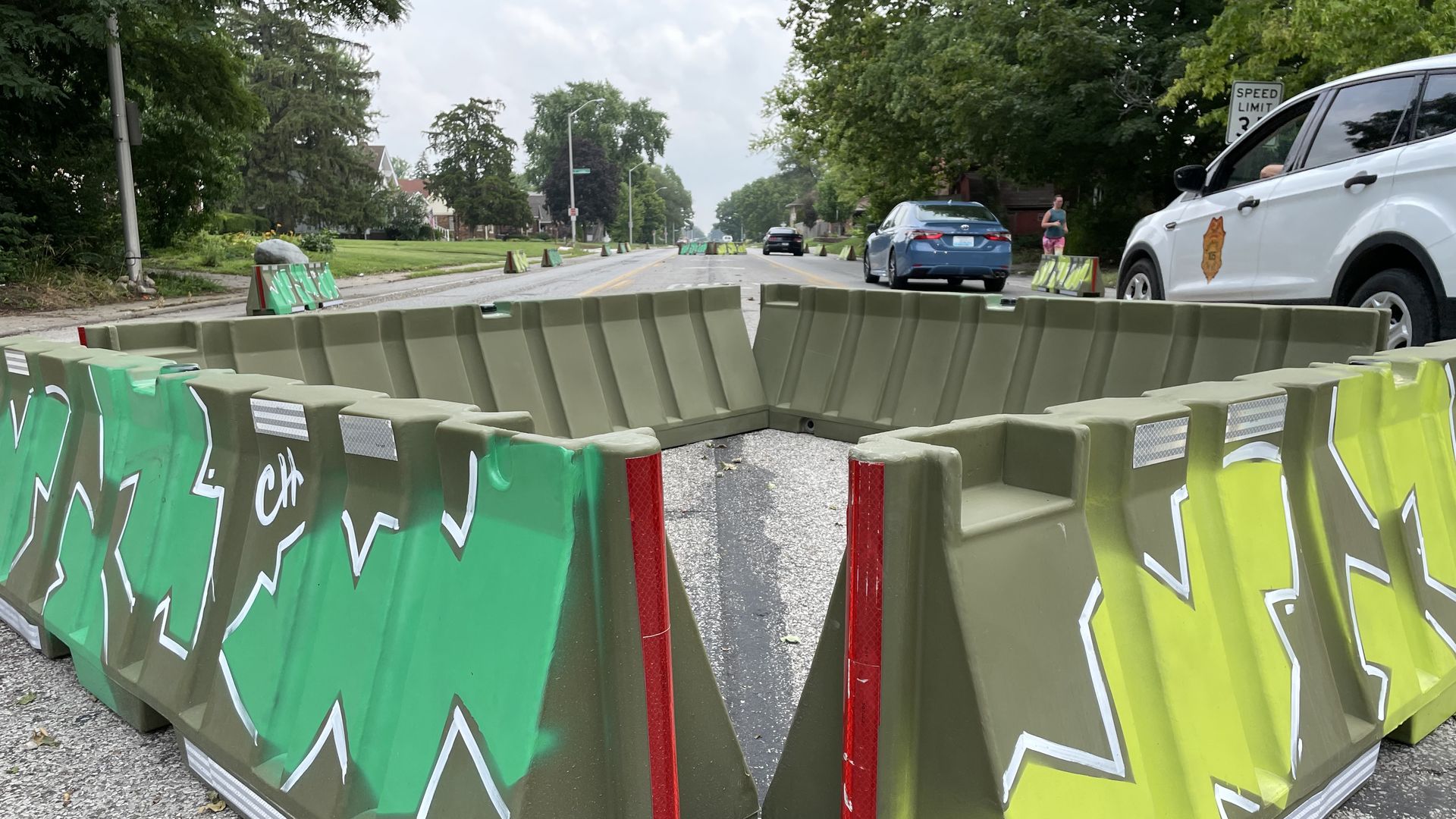 Barriers in the middle of East 10th Street narrow the street width.