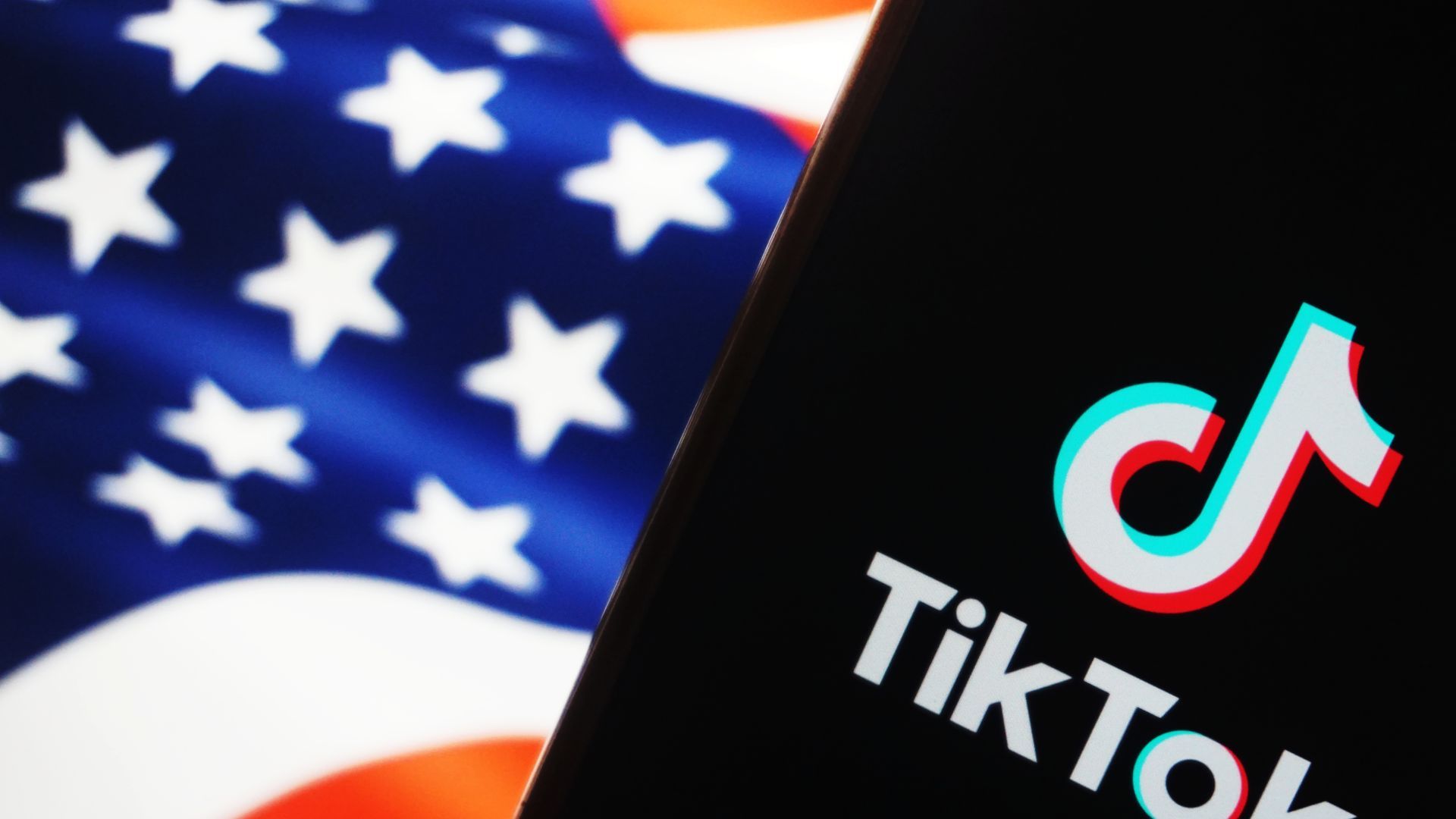 A photo illustration of a smartphone with a TikTok logo on the screen in front of an American flag