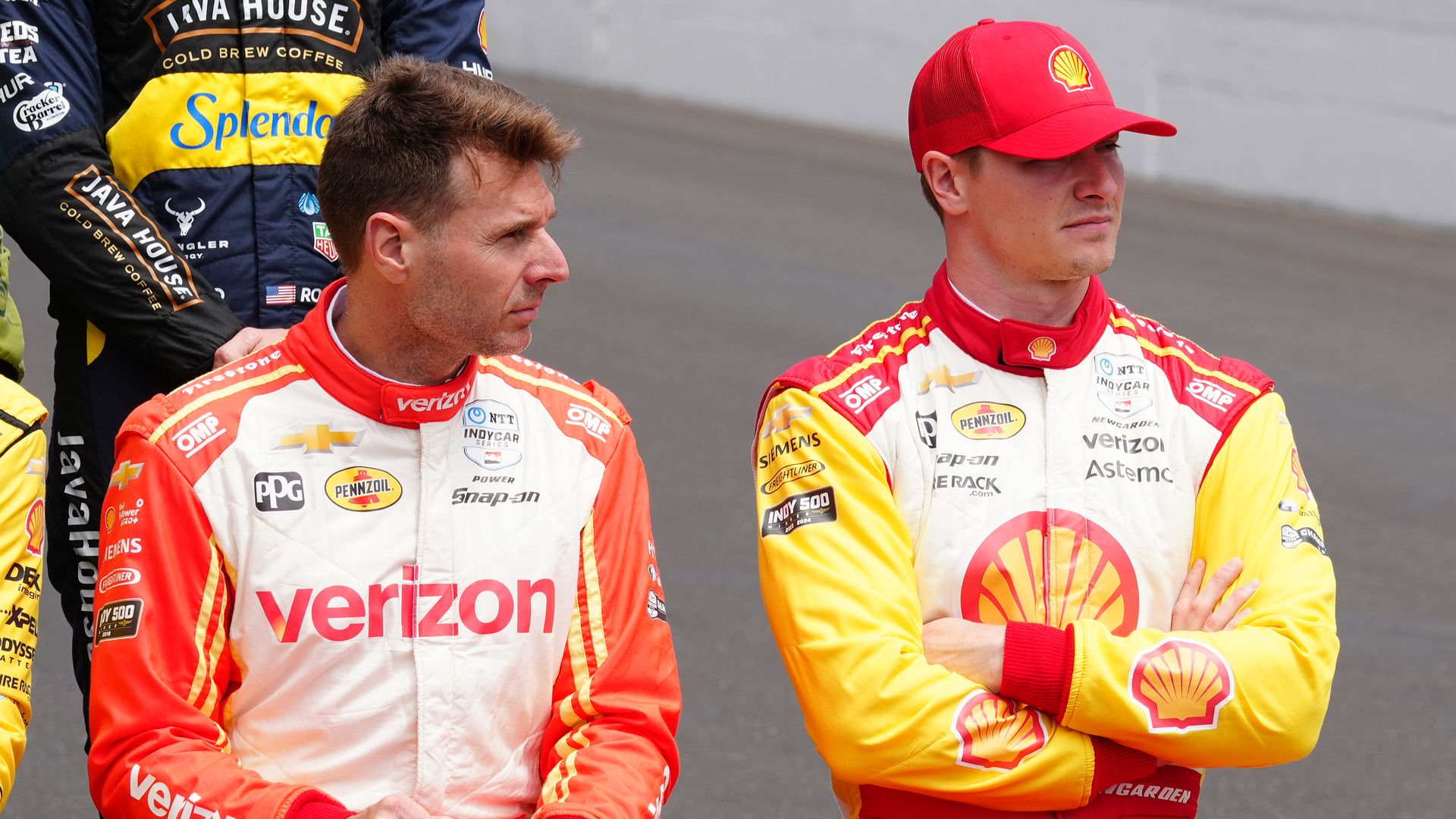 Two race car drivers sitting in fire suits