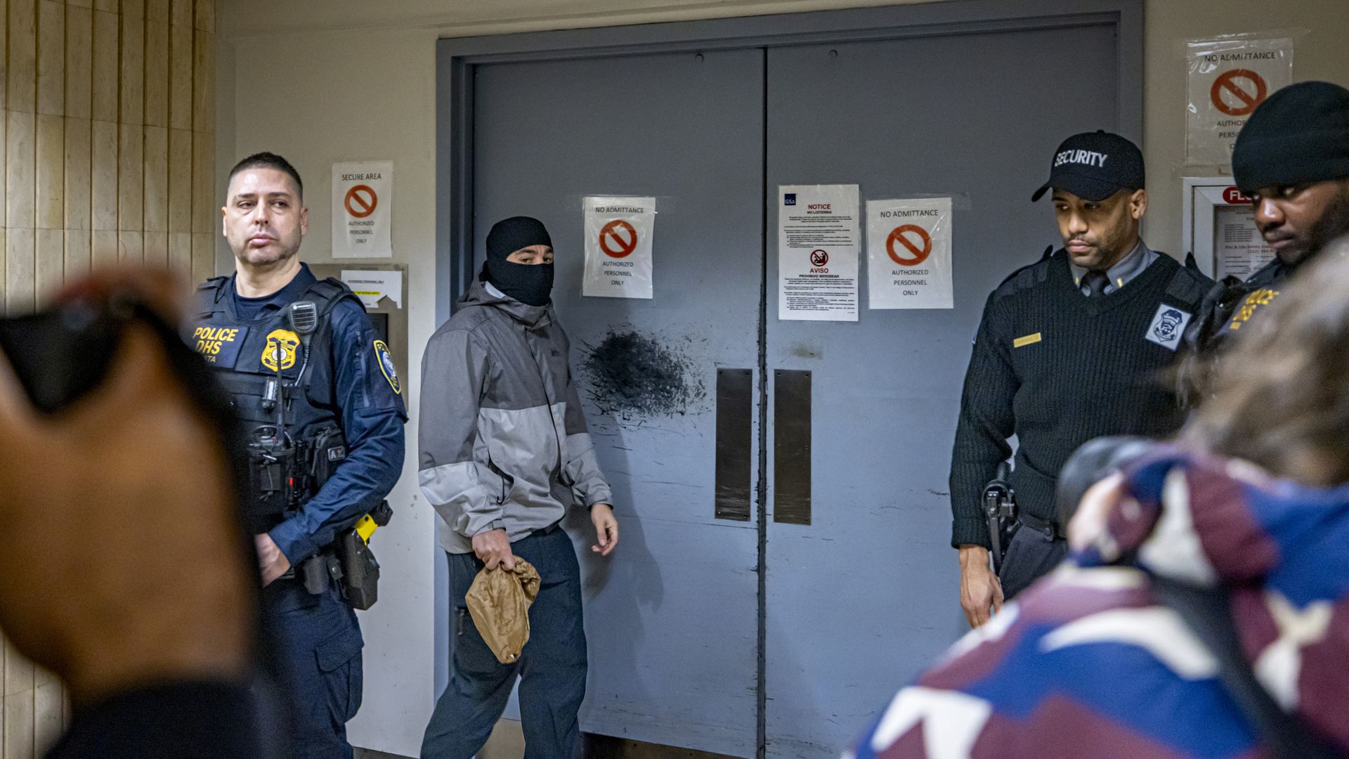 Federal agents gathered around a courthouse door.