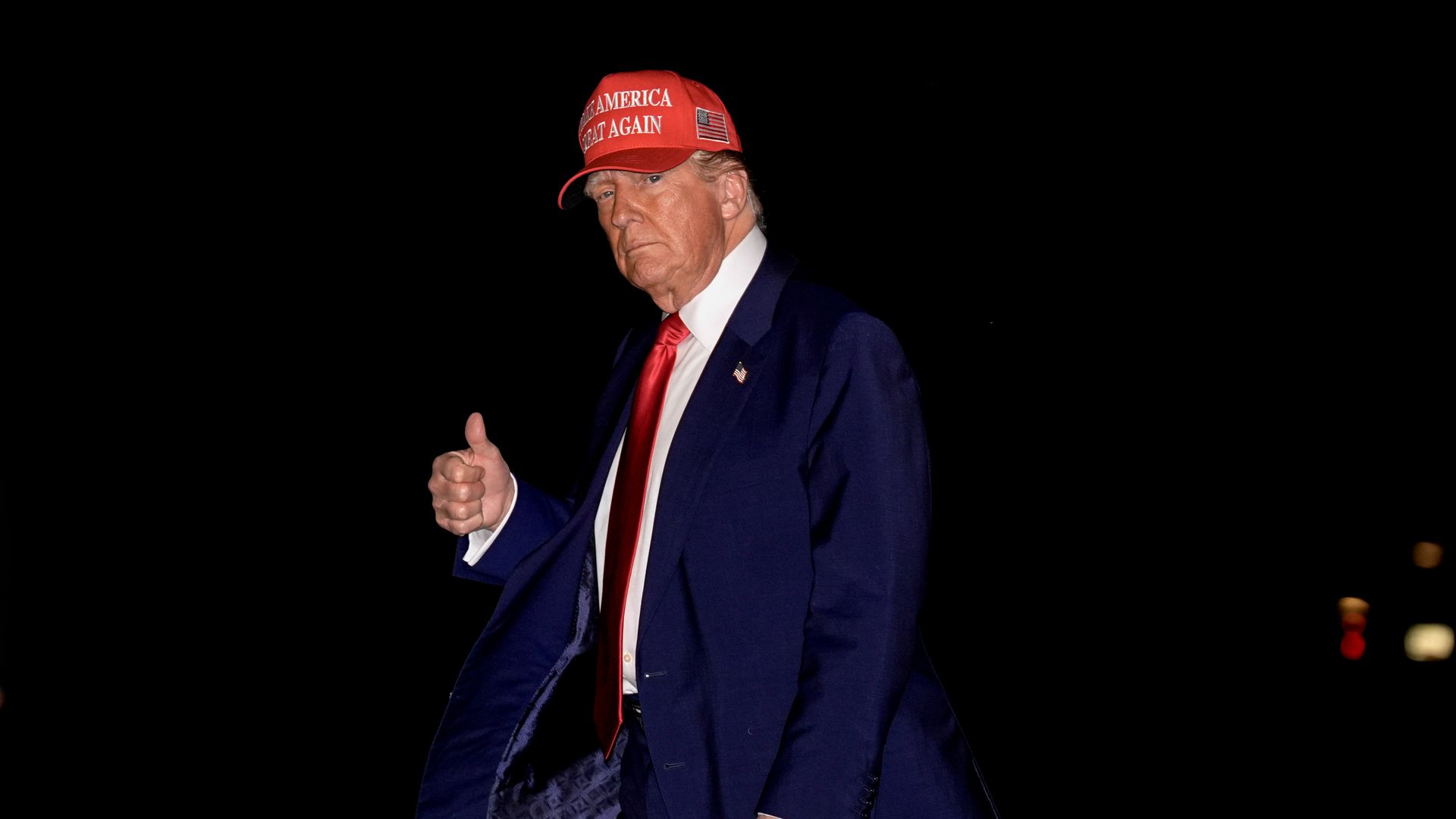 Trump walks in the dark with a thumbs up