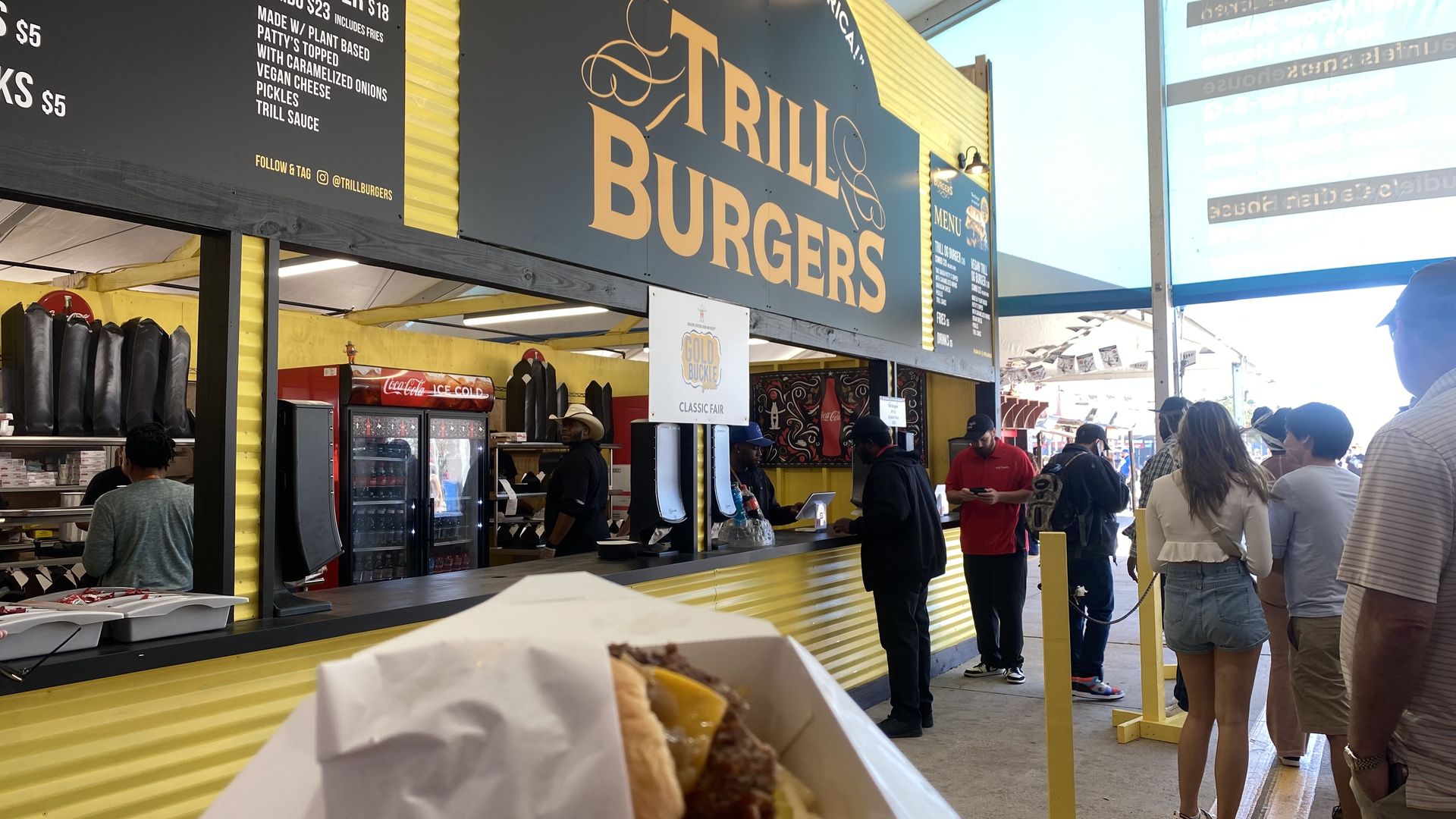 Photo of a burger in front of "Trill Burgers" stand