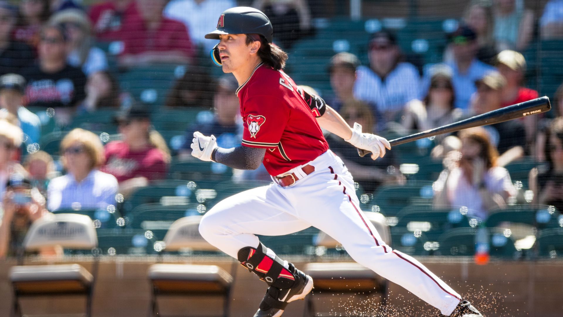 A baseball player in an Arizona Diamondbacks uniform hits a ball. 