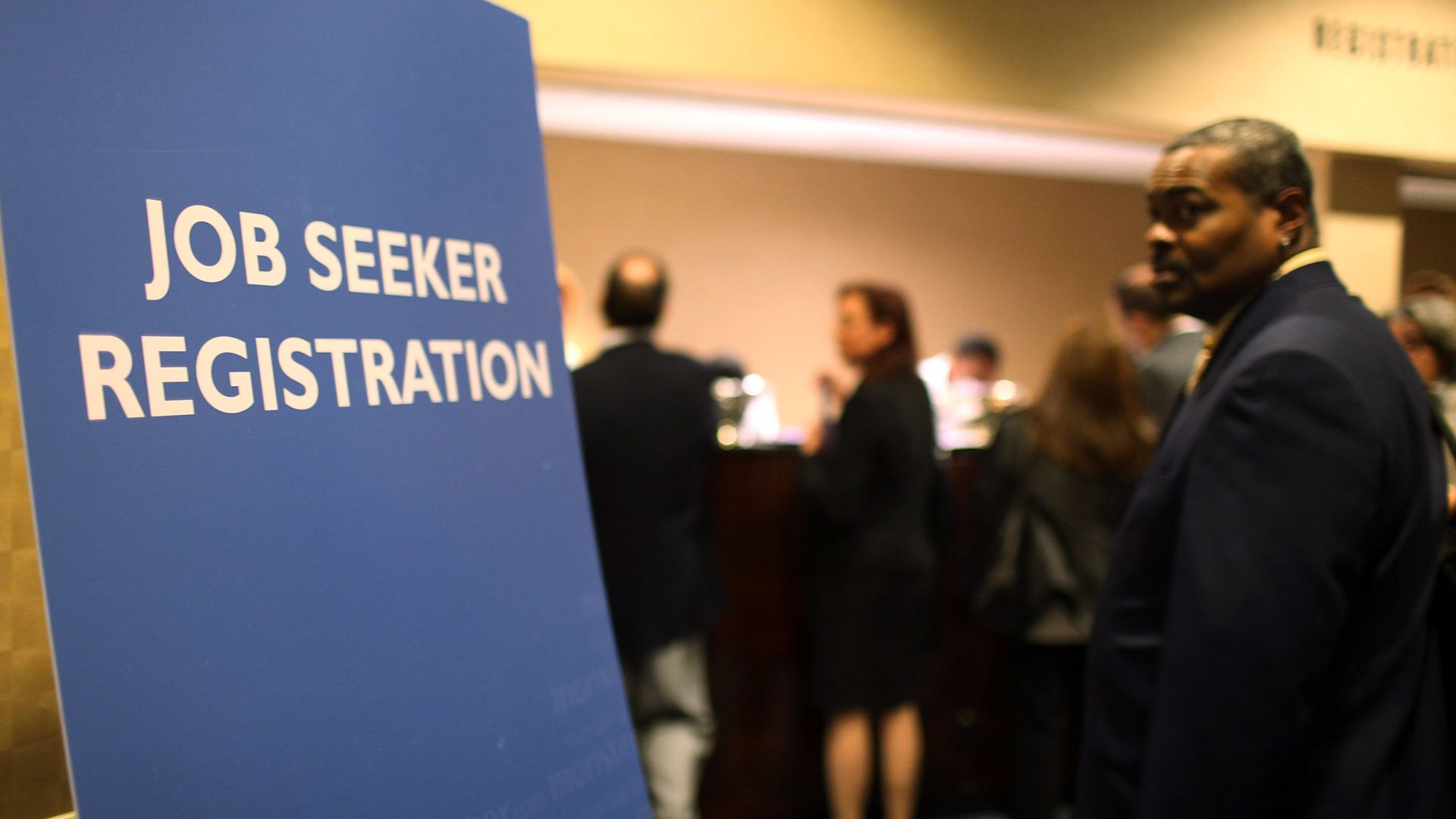 People wait in line at a job fair sponsored by Monster.com